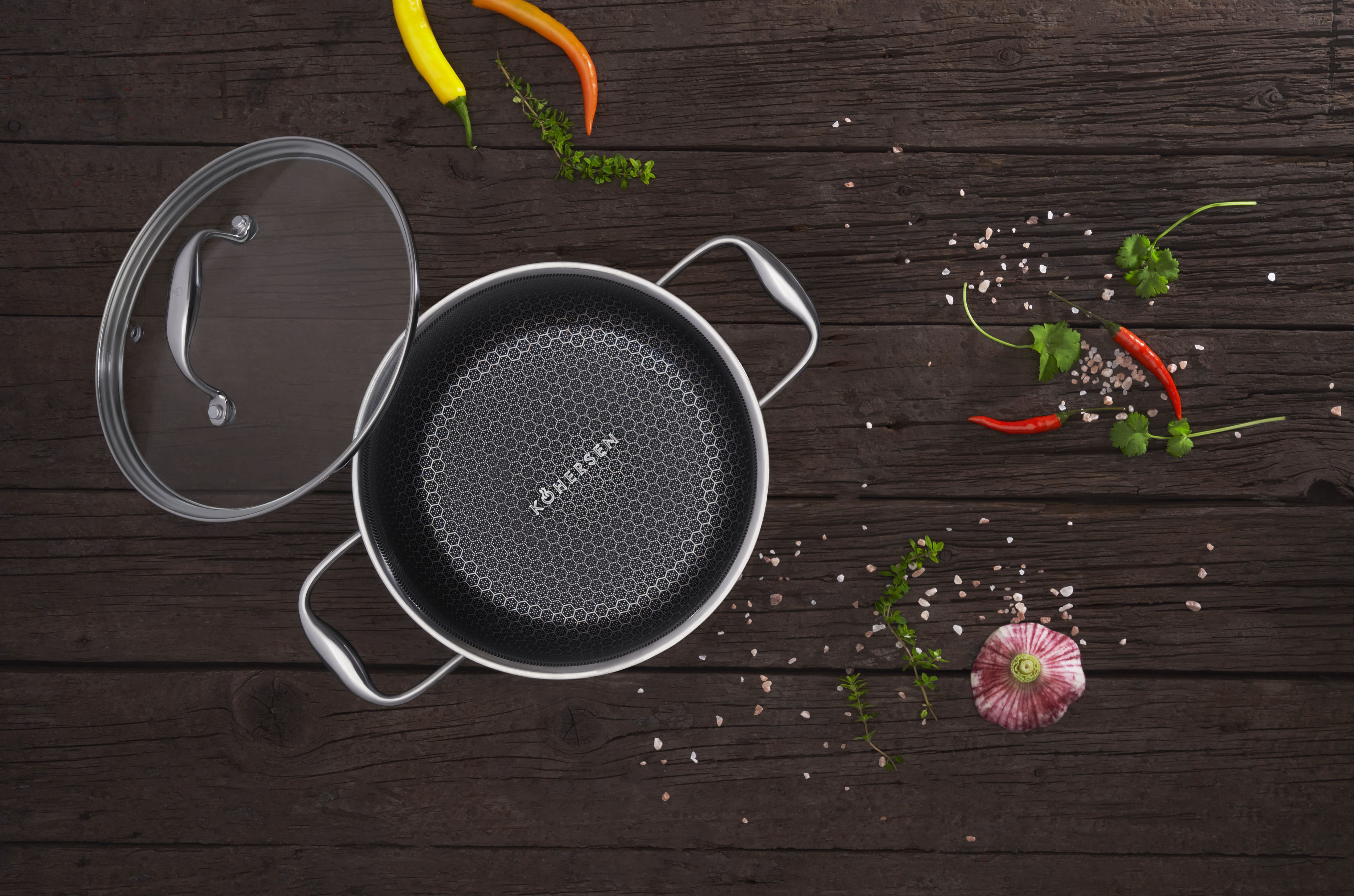 Patelnia z jedzeniem, przyprawami i dodatkami na drewnianym stole. Widok z góry.