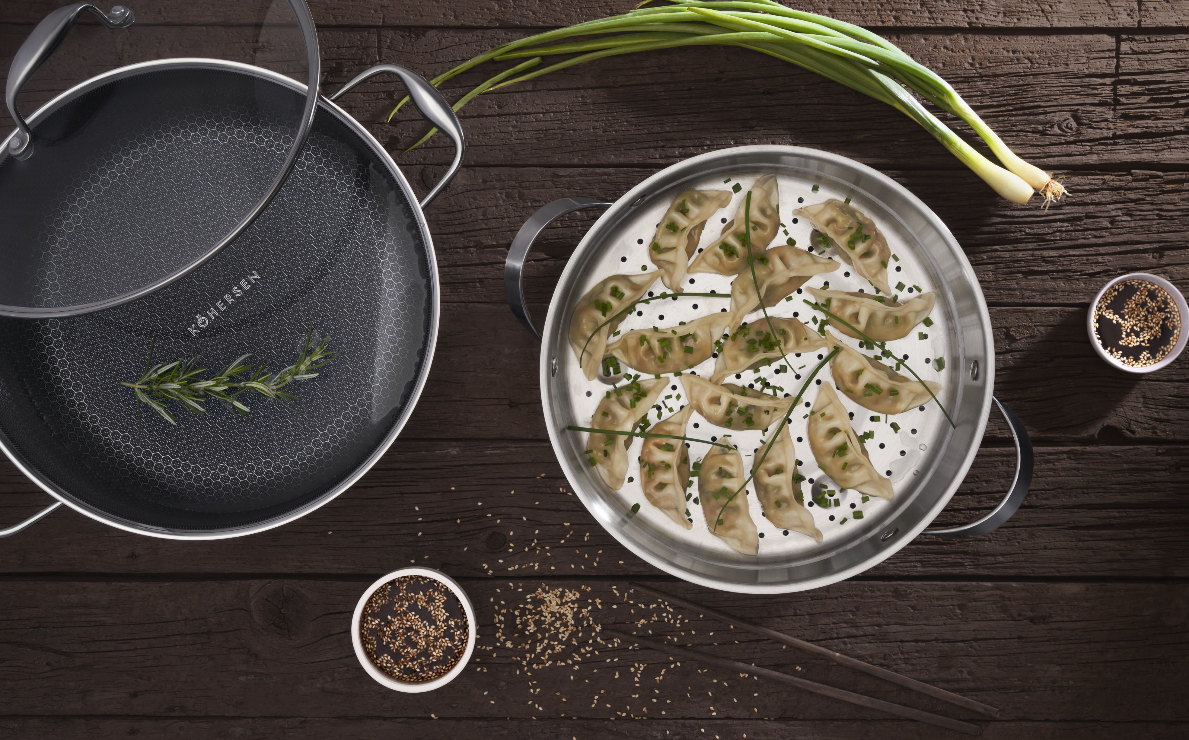 Patelnia z pierożkami, patelnia z rozmarynem i przyprawami na drewnianym stole.