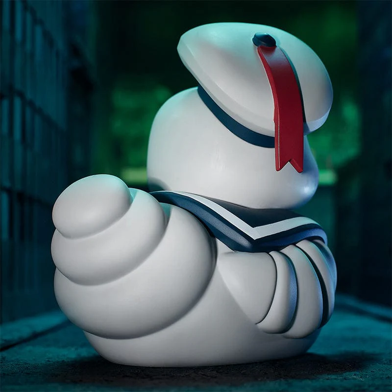 Fehér Stay Puft Marshmallow Man figura, tengerészsapkával és piros szalaggal. Sötétkék részletek. Sötét háttér.