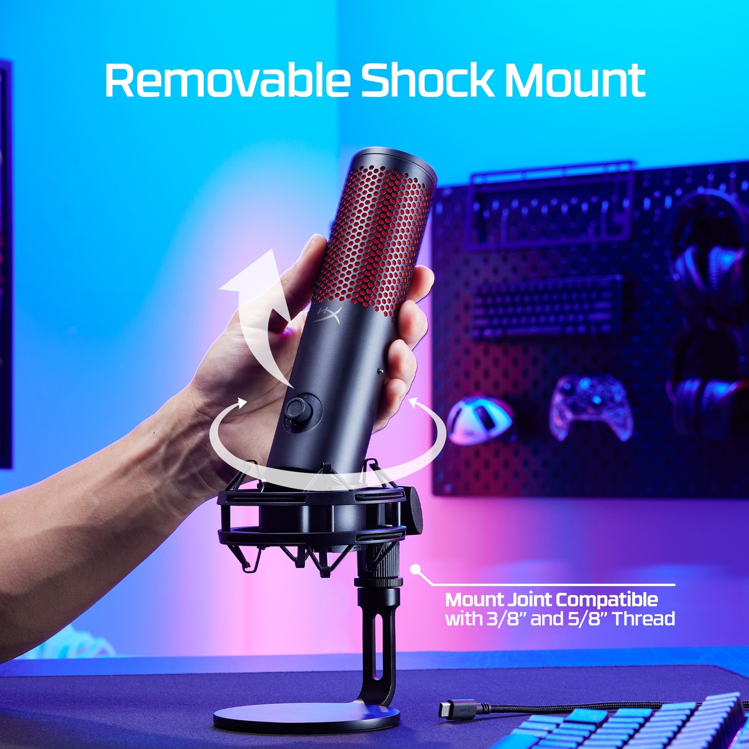 Un microphone noir avec une grille rouge sur un support, tenu par une main.