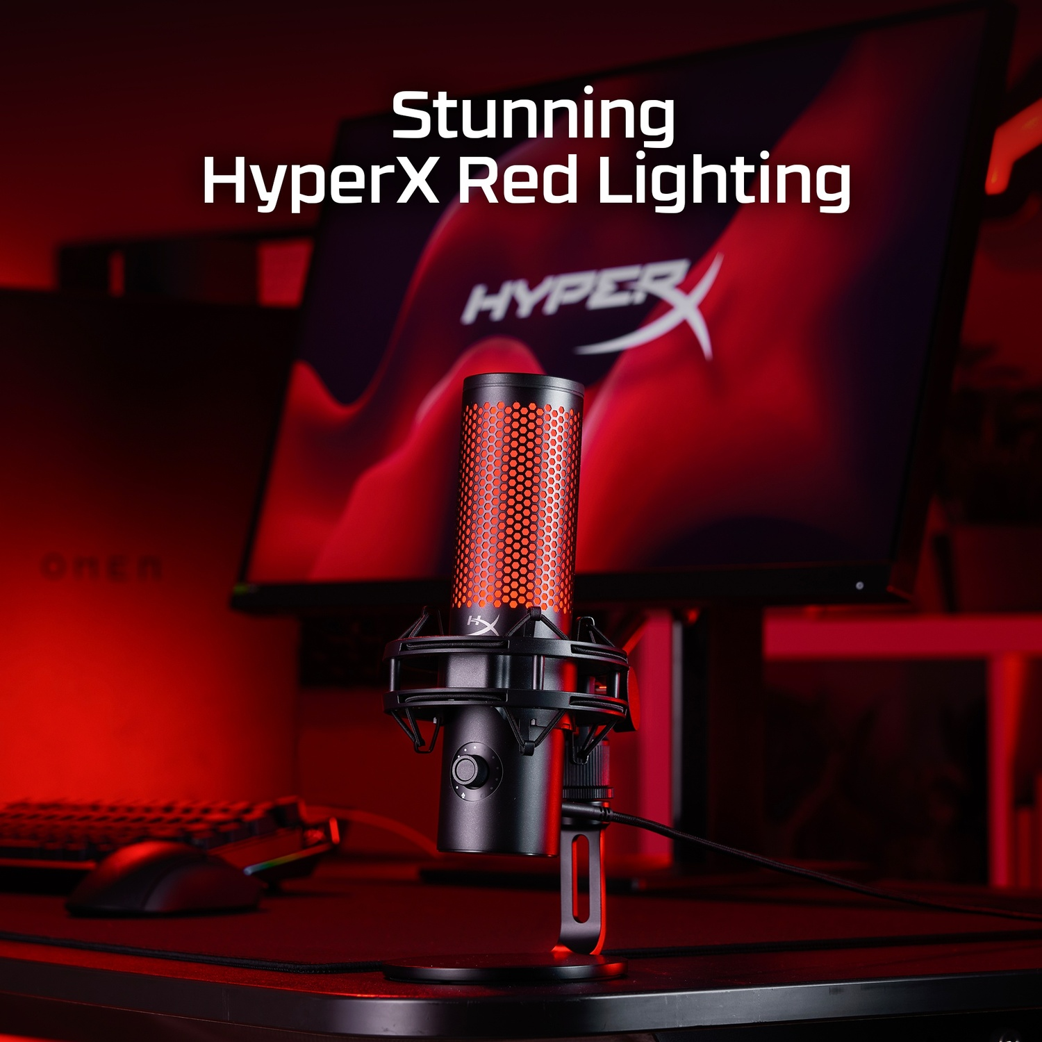 Microphone HyperX, noir avec éclairage rouge, sur un bureau, fond rouge.