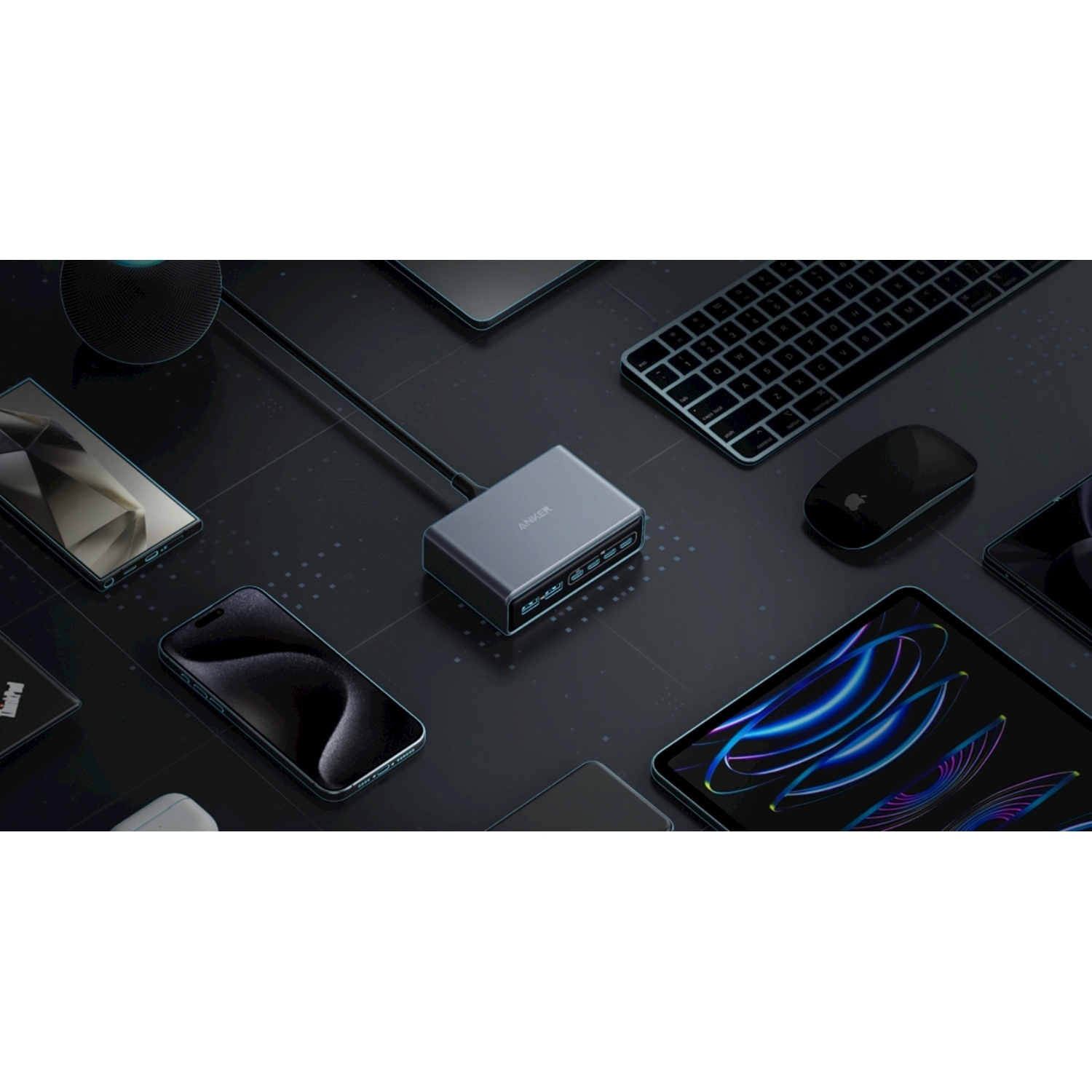 Una superficie scura con telefoni, un tablet e un hub. Sono visibili una tastiera e un mouse.
