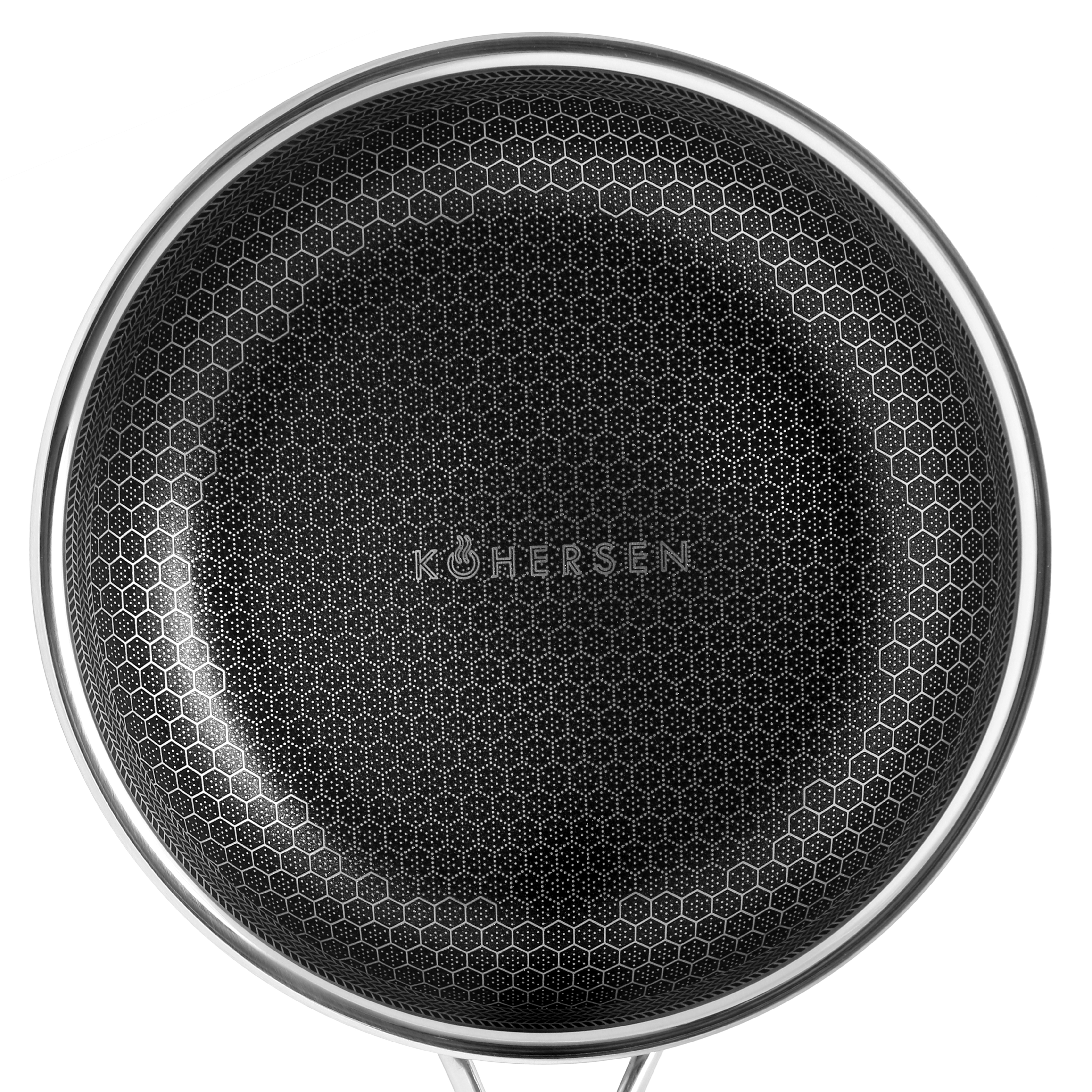 Widok z góry na patelnię z wnętrzem o wzorze plastra miodu i metalową obręczą, na białej powierzchni.