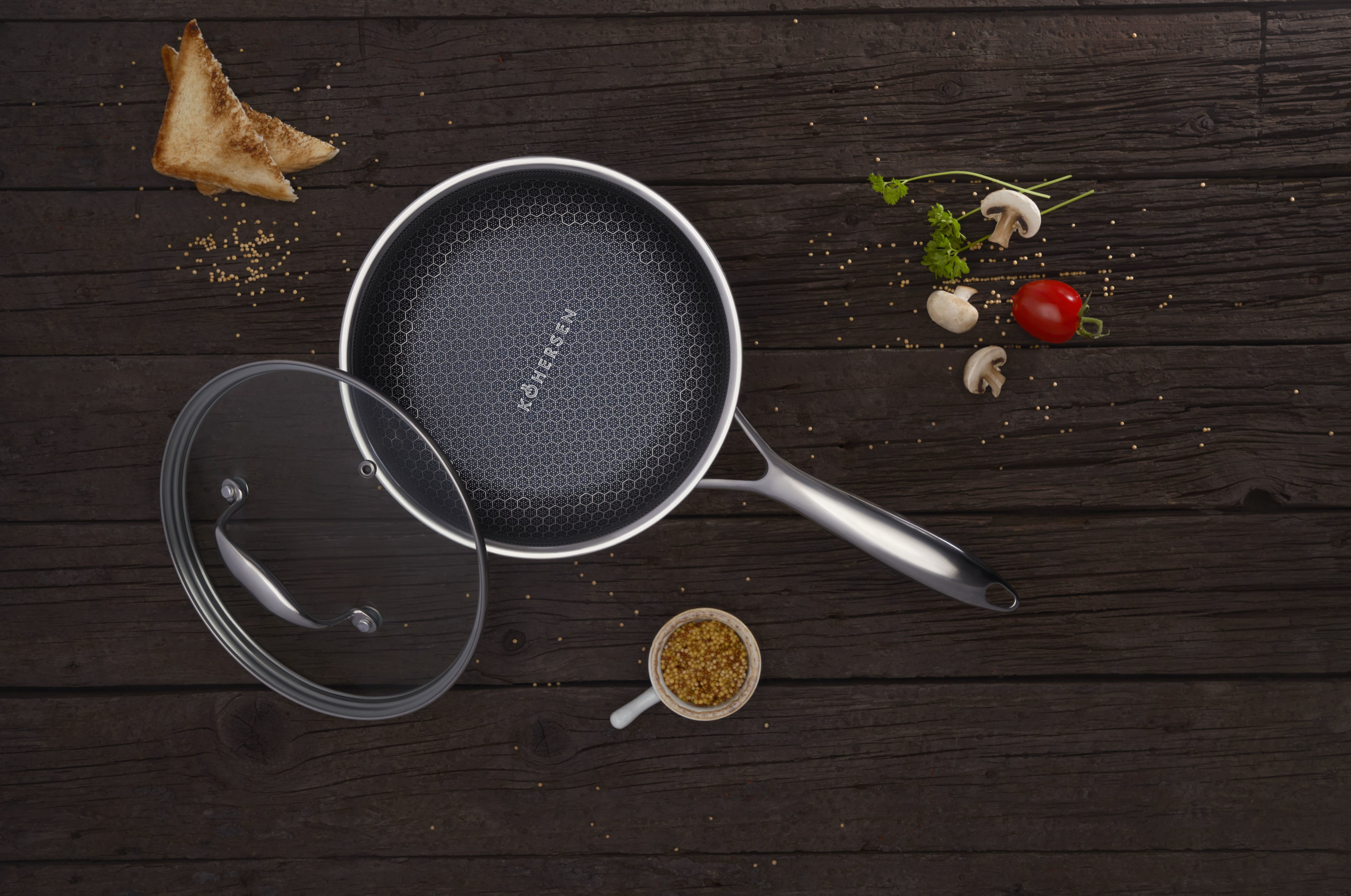 Patelnia z pokrywką i składnikami, na ciemnej drewnianej powierzchni. Widok z góry ze składnikami.