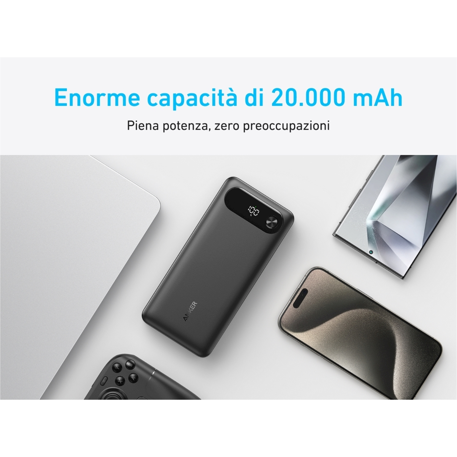 Power bank nero con display e telefoni. È su una superficie bianca con un laptop e un controller di gioco.