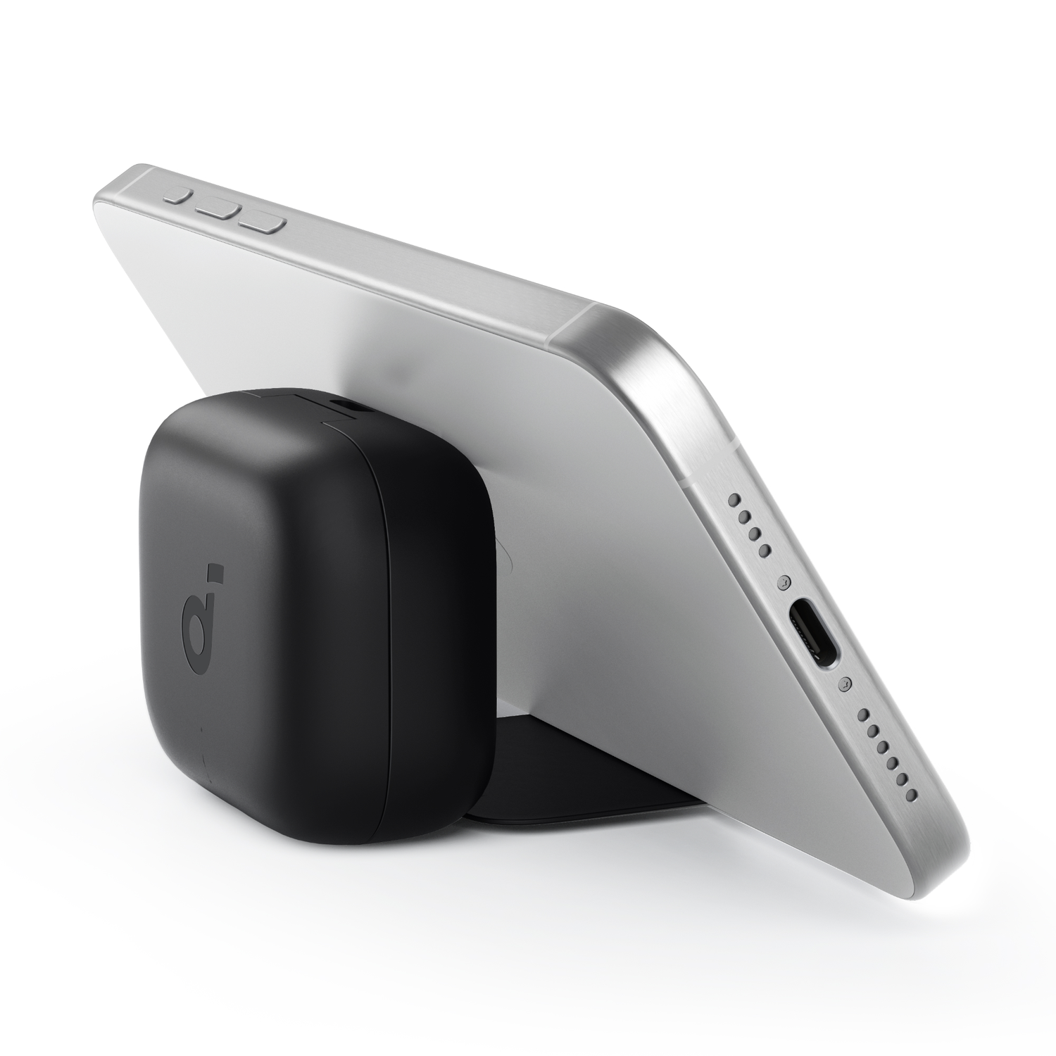 A silver tablet rests on a black Anker charging device.