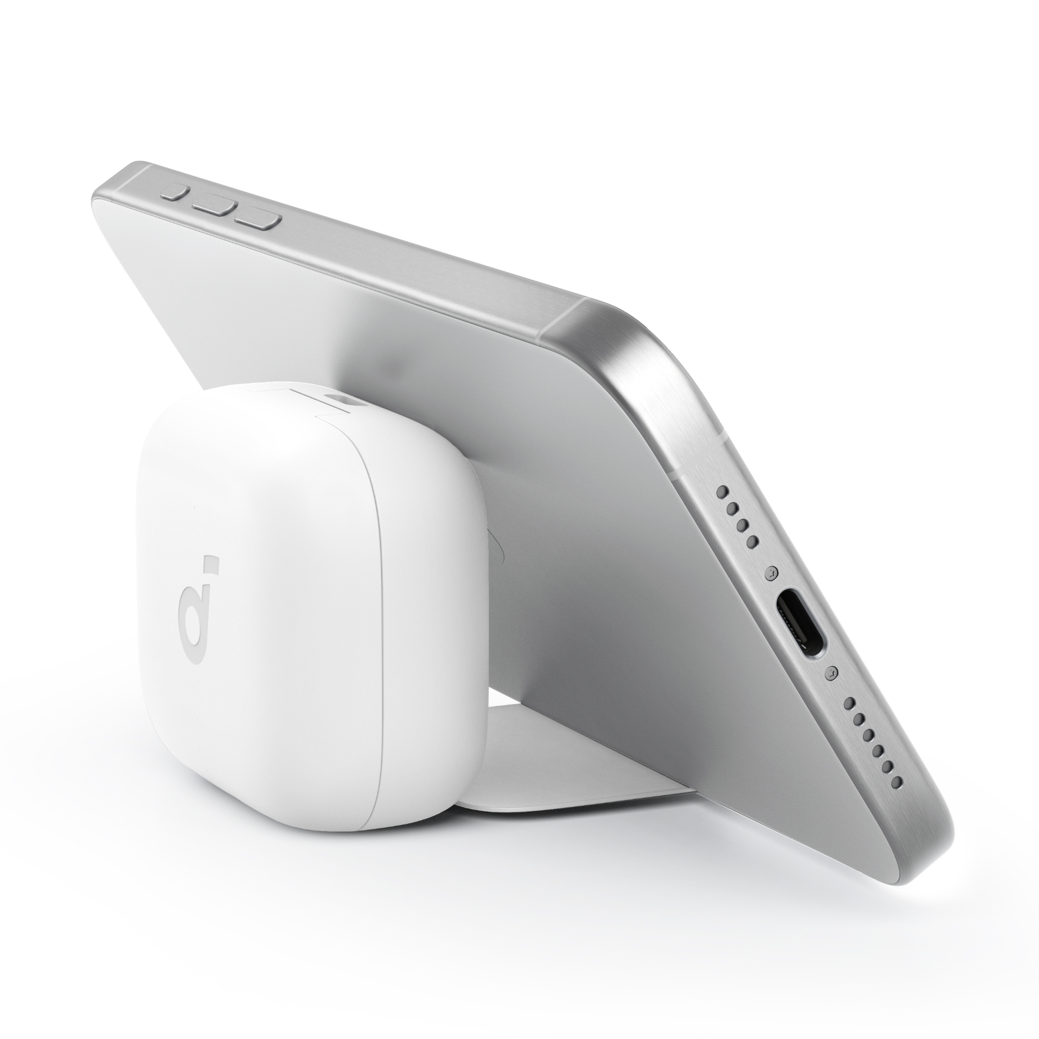 Witte telefoon staat op een witte basis, leunend tegen een wit rechthoekig oplaadpad.