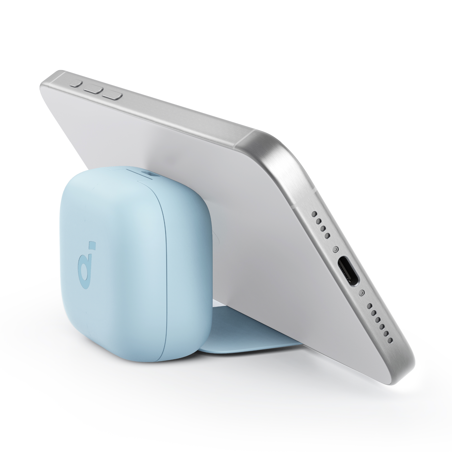 A silver tablet rests on a light blue Anker charging device.