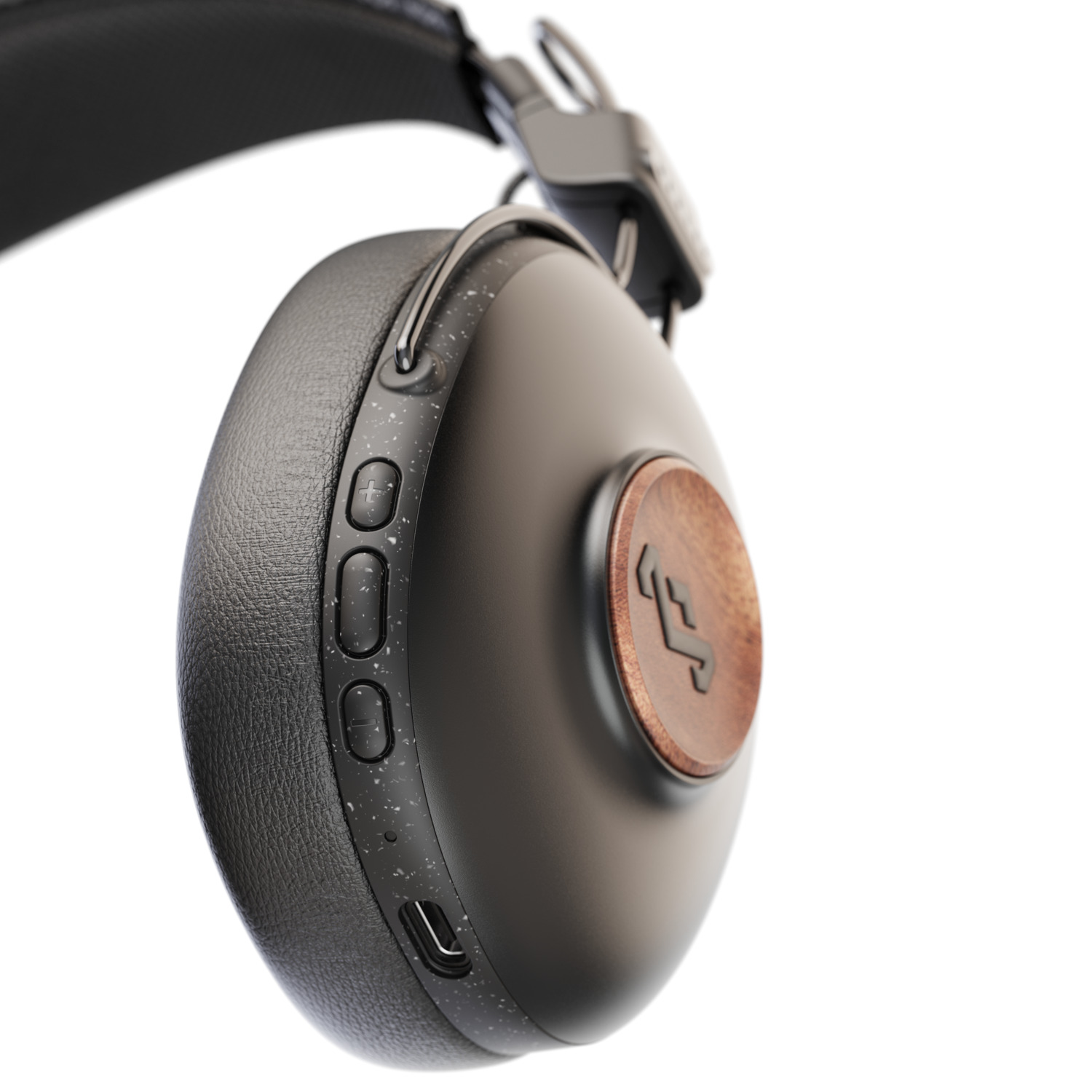 Détail d'un casque noir et grain de bois, montrant les boutons et l'écouteur.