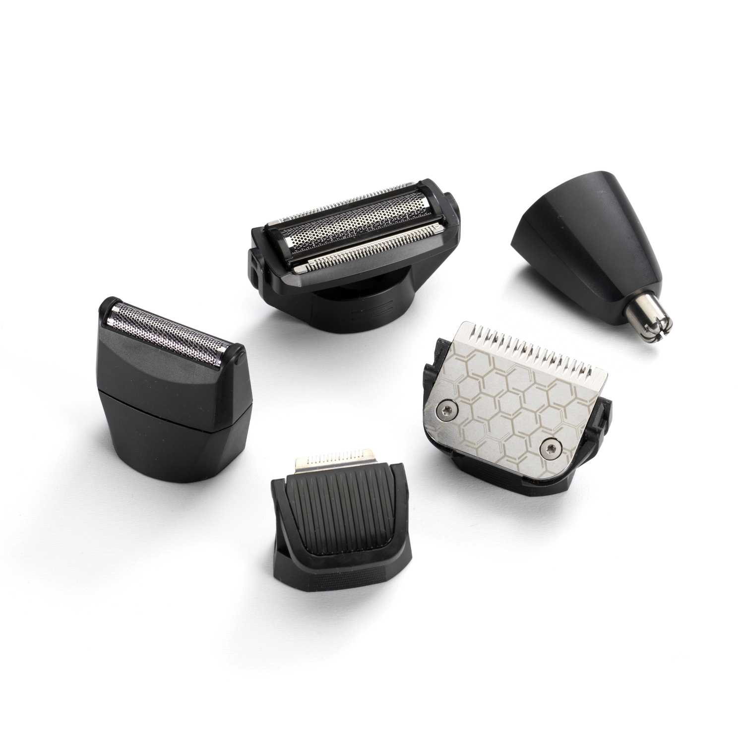 Multiple shaving heads and trimmer attachments, arranged on a white surface.