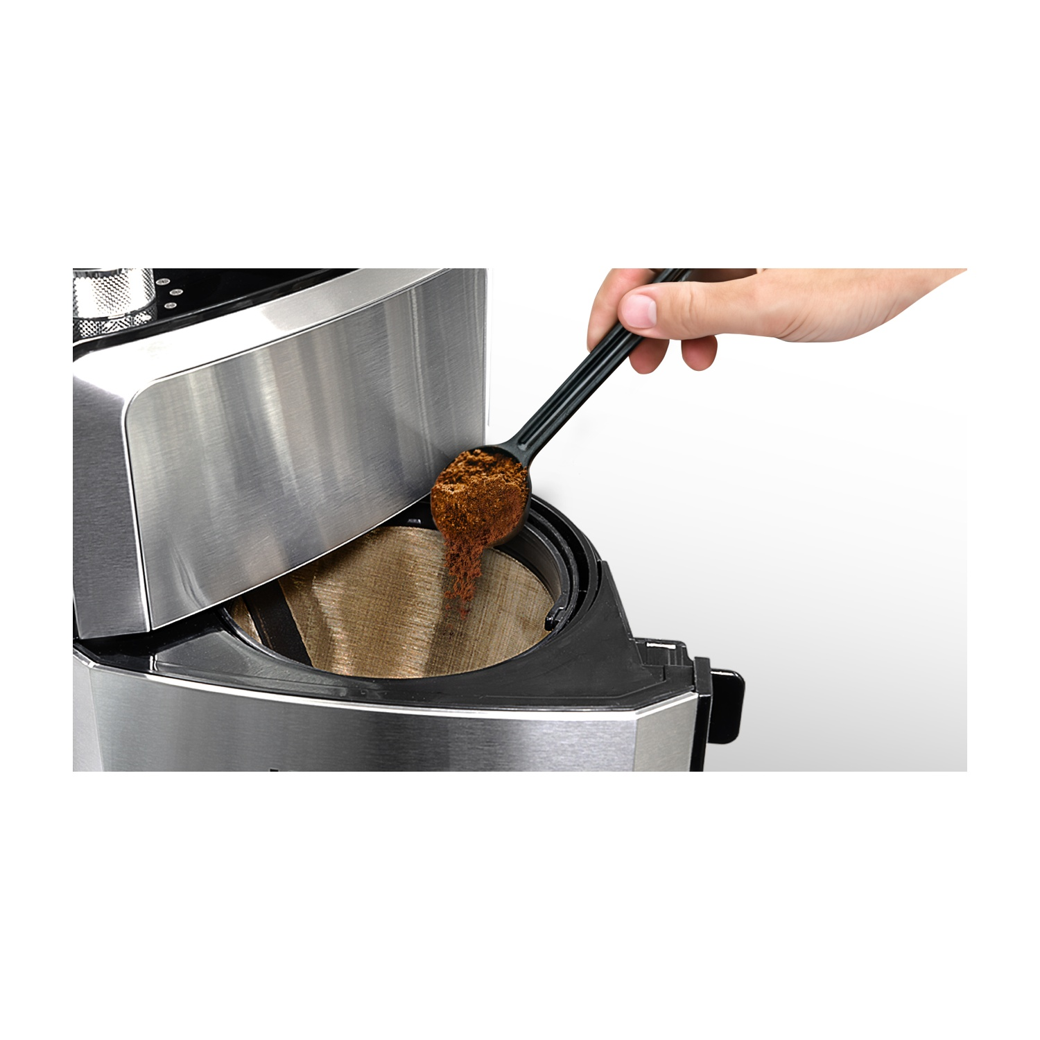 Una mano aggiunge caffè macinato a una macchina per il caffè con un cucchiaio nero. Sfondo bianco.