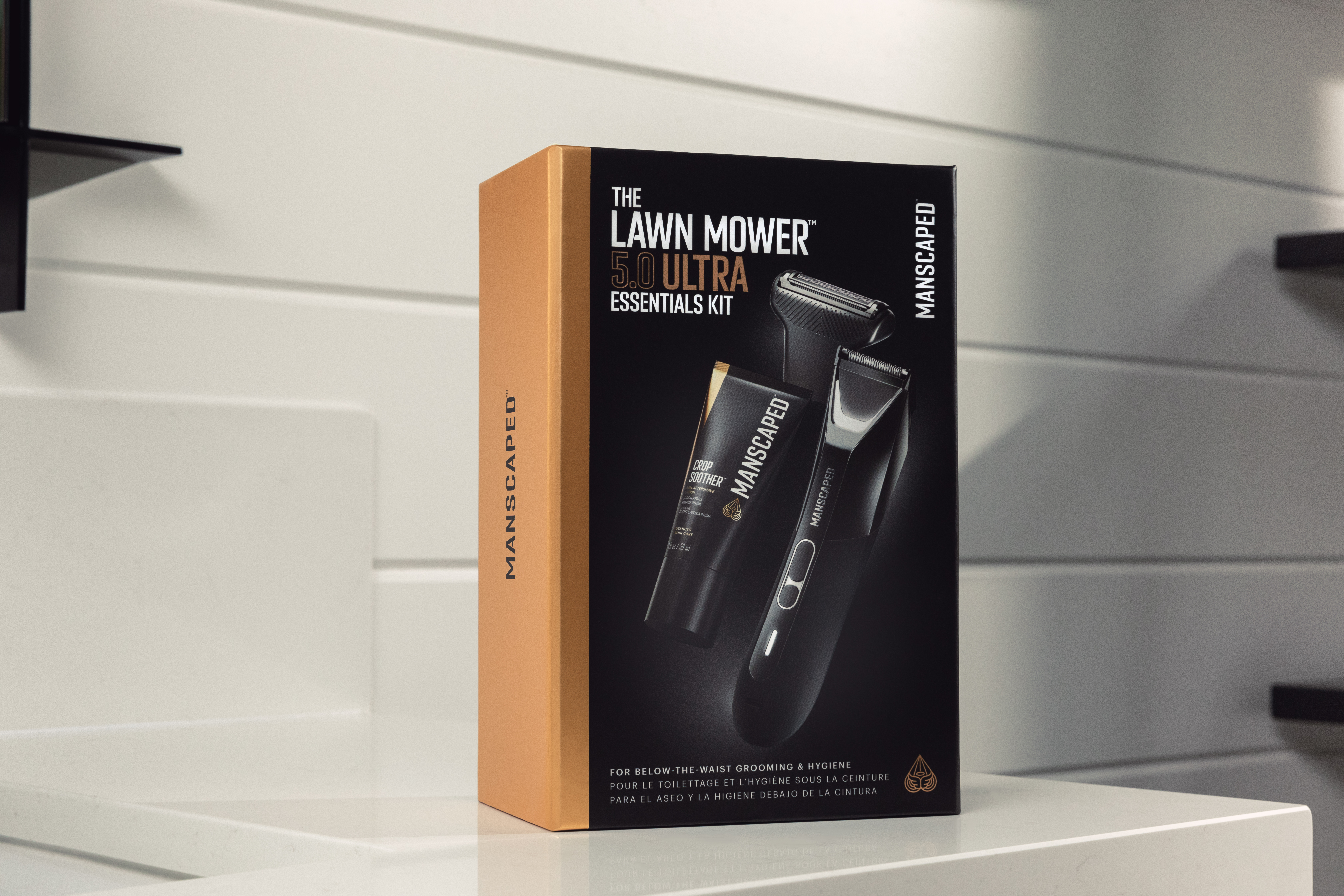 Box mit Pflegekit mit Trimmer und Rasierprodukten. Orange und Schwarz.