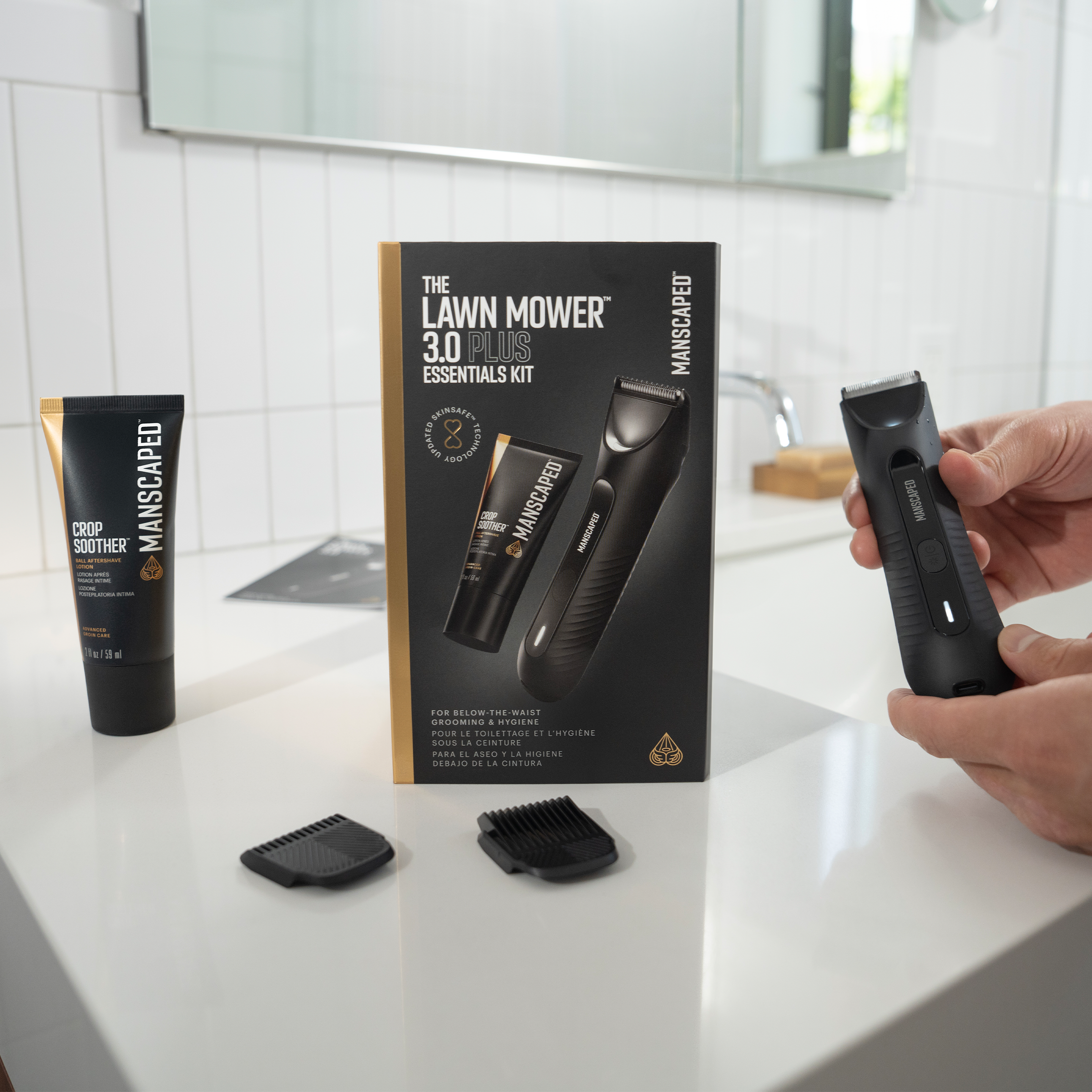 Manscaped Pflege-Set mit Trimmer, Creme und Aufsätzen auf weißer Oberfläche im Badezimmer.