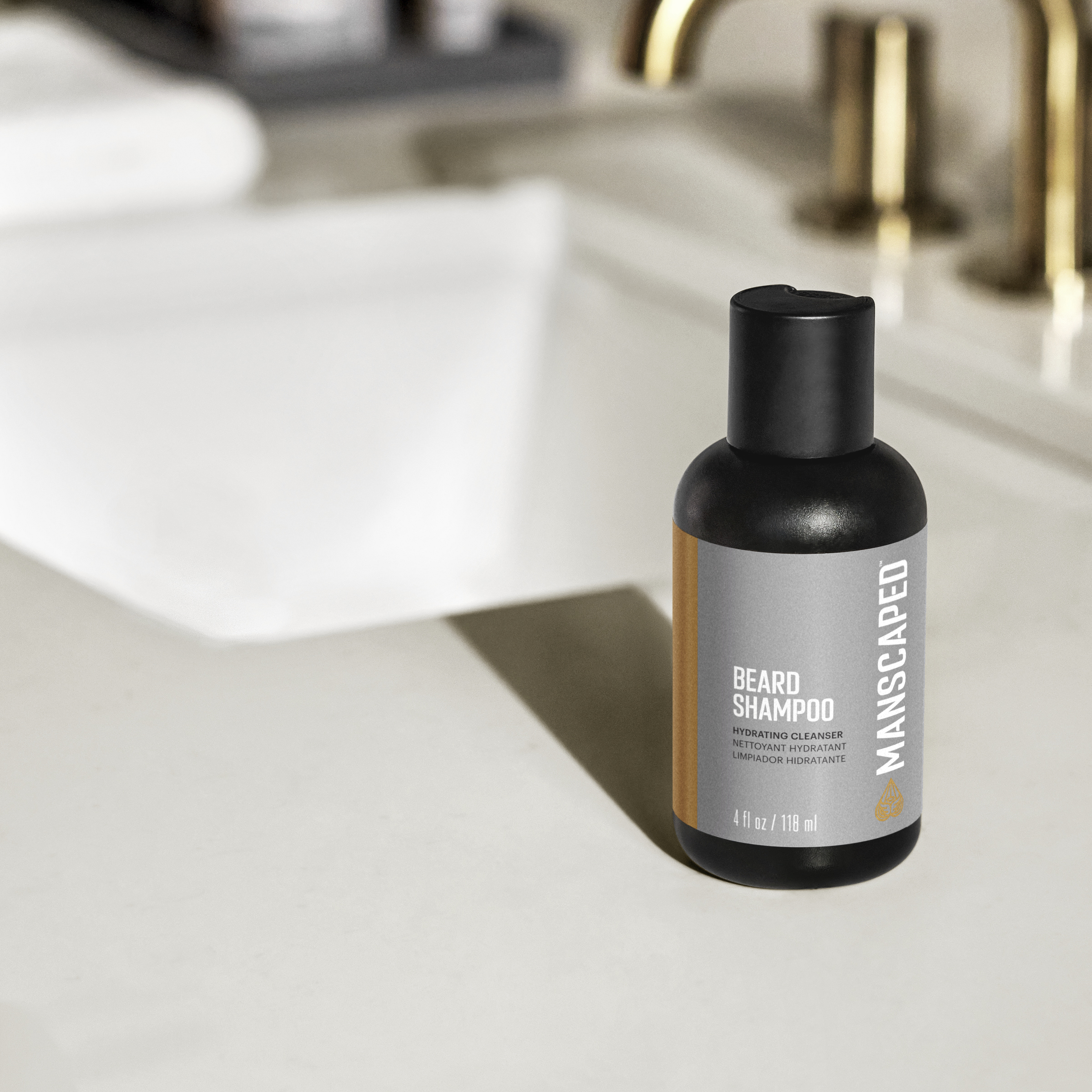 Bouteille de shampooing à barbe Manscaped noire. Étiquette blanche avec texte. Salle de bain, lavabo et miroir.