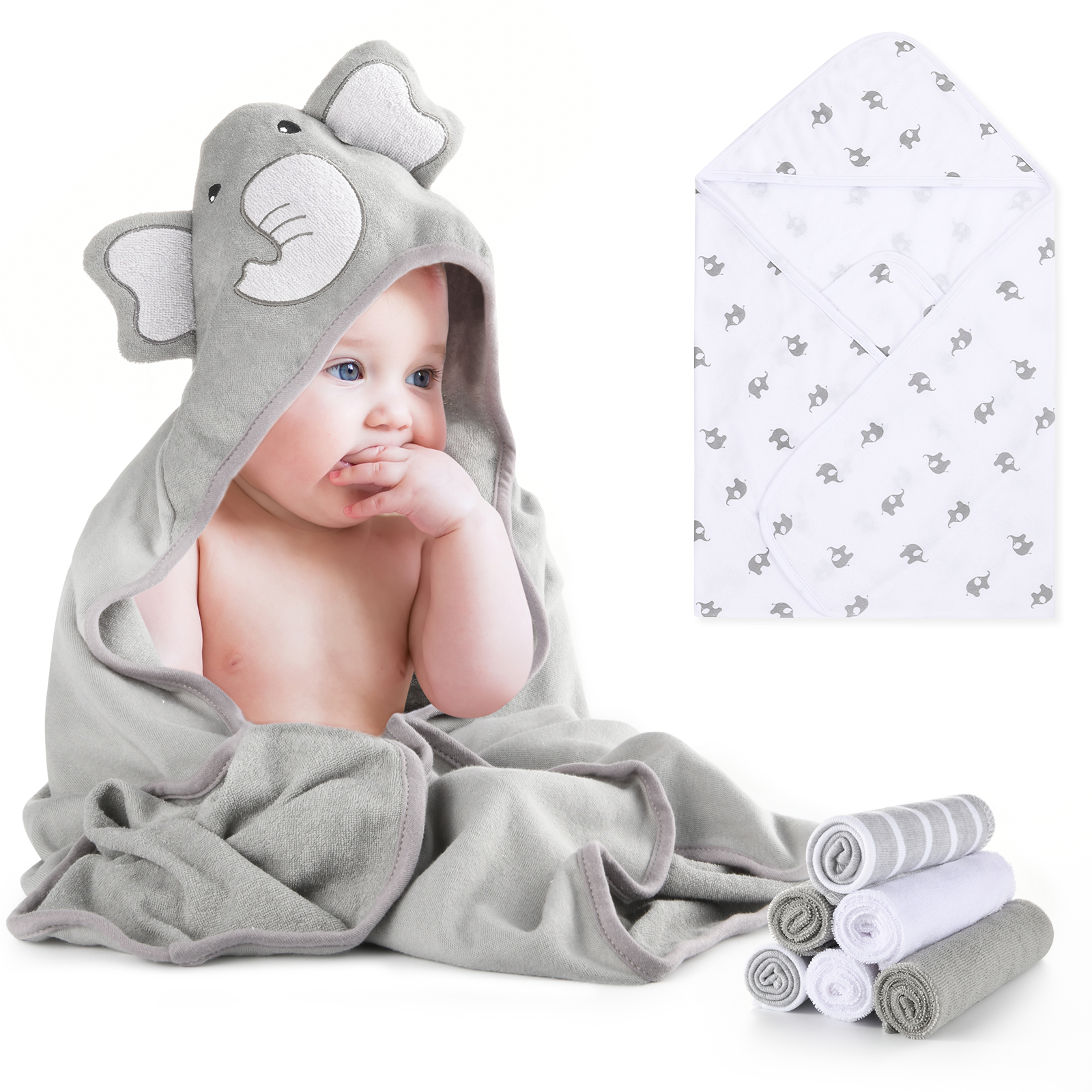 Baby in grauem Elefanten-Kapuzenhandtuch, neben Handtüchern und einer Babydecke.