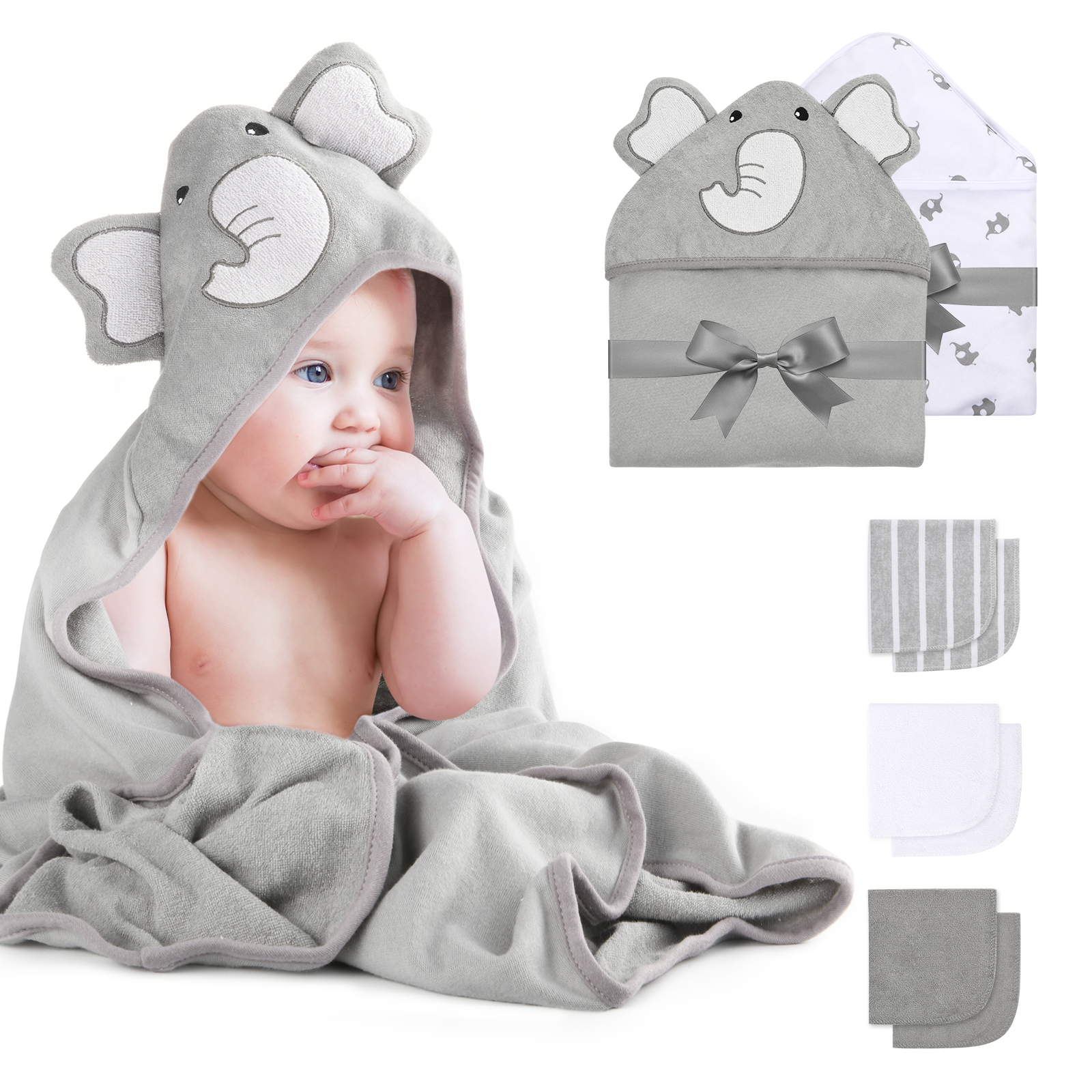 Ein Baby, eingewickelt in ein graues Handtuch mit Elefantenkapuze, mit anderen Handtüchern in der Nähe.