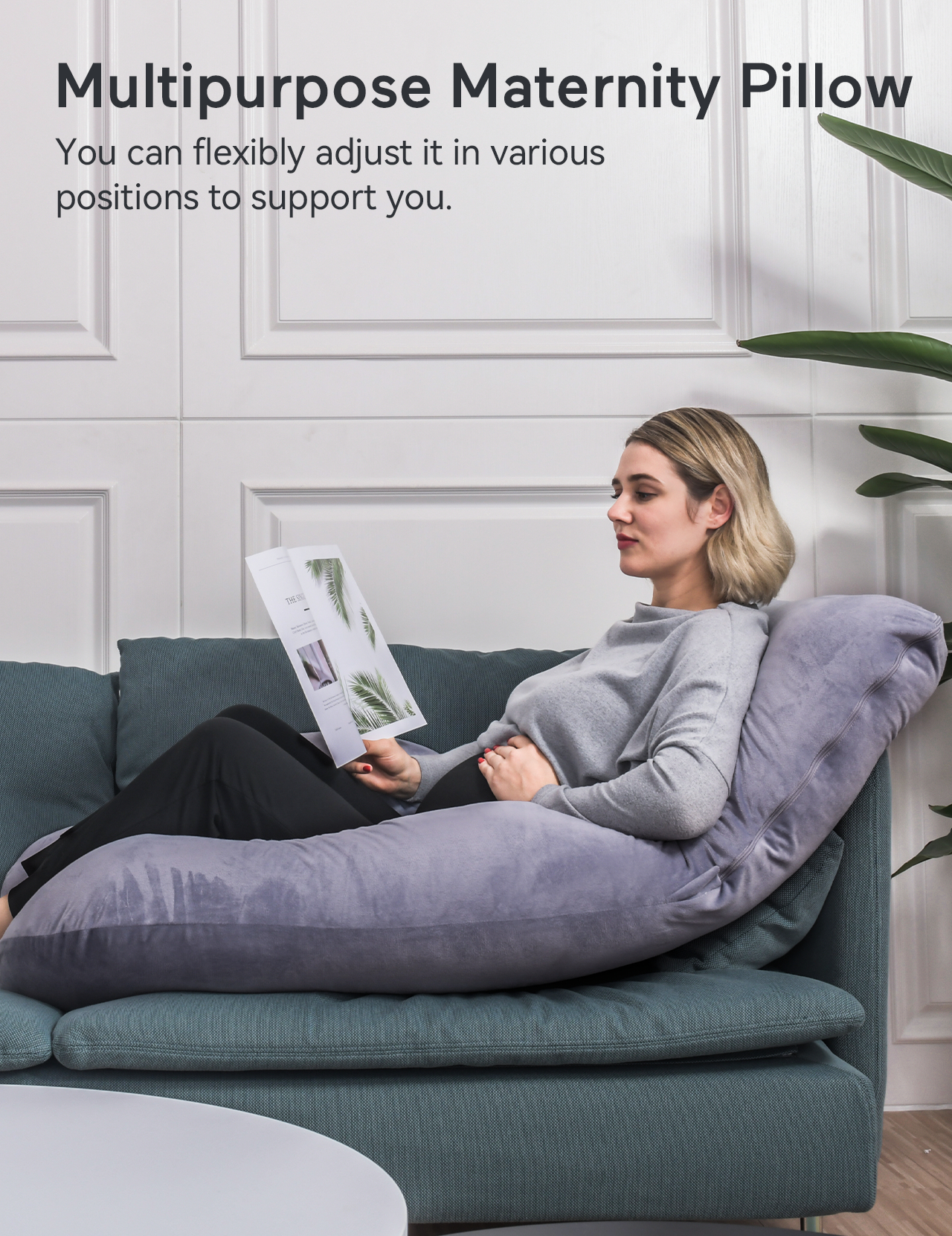 Frau auf einem Sofa mit einem Umstandskissen, liest eine Zeitschrift.