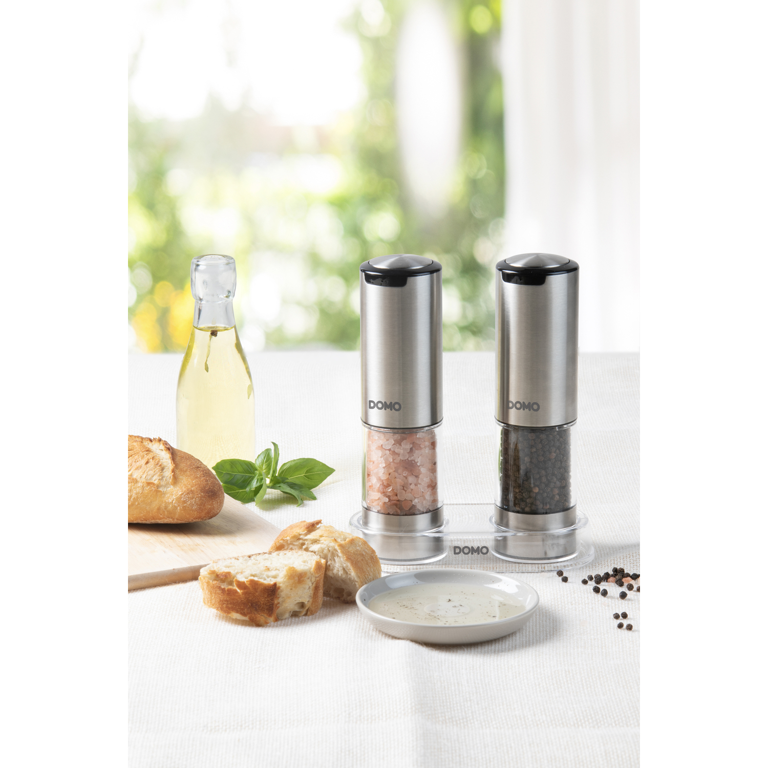 Salt and pepper grinders with ingredients on a table.