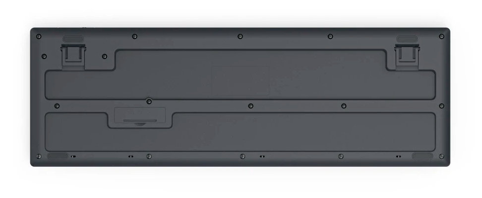 Widok od spodu ciemnoszarej klawiatury ze szczegółami śrub i komorą na baterie.