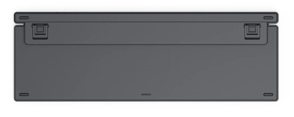 Ciemnoszara klawiatura widziana od dołu. Ma gumowe nóżki i mały otwór.