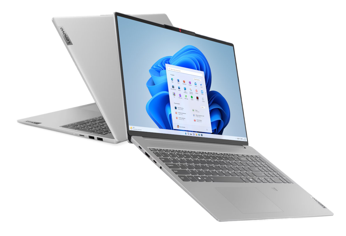 Srebrny laptop, otwarty na białej powierzchni, z drugim laptopem z tyłu.