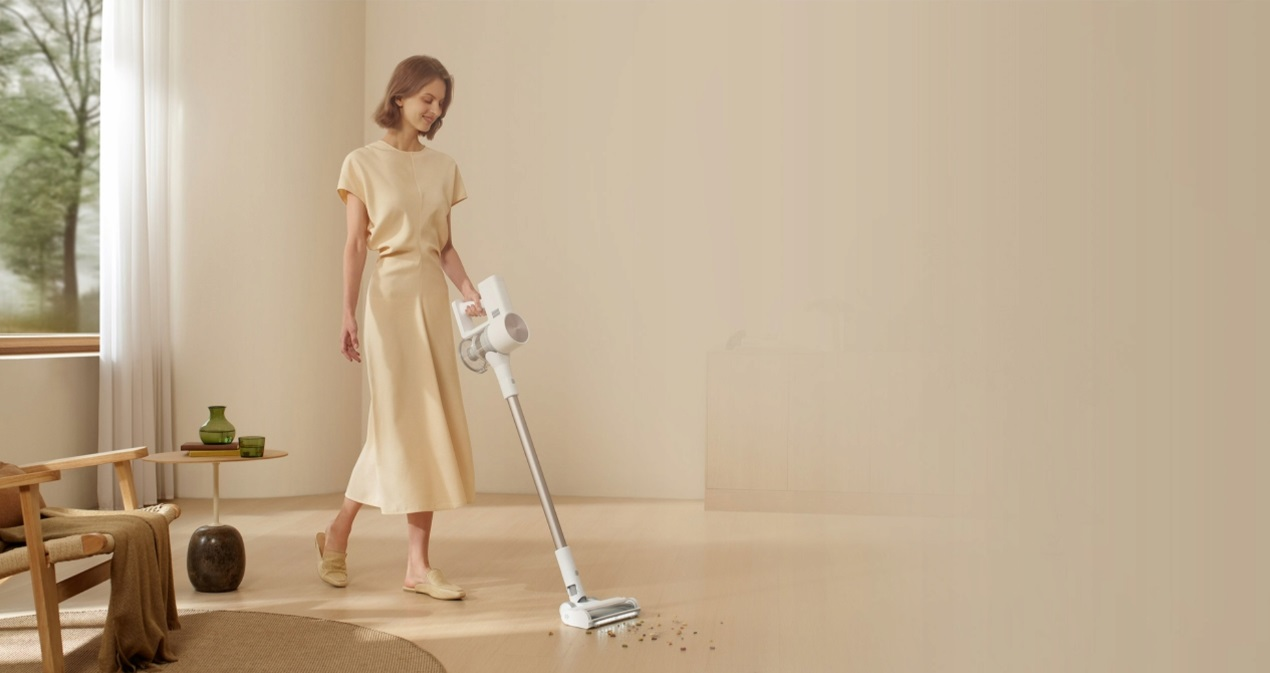 Kobieta odkurzająca pokój za pomocą odkurzacza.