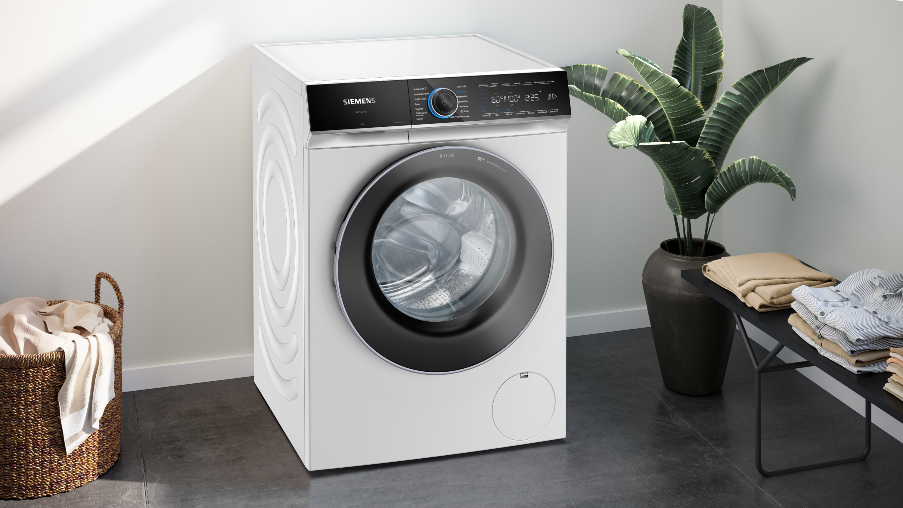Eine weiße Siemens Waschmaschine mit Digitalanzeige und einer Pflanze.