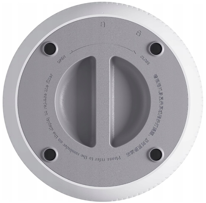 Białe, okrągłe dno urządzenia. Zawiera wskaźniki otwierania/zamykania i cztery czarne nóżki.