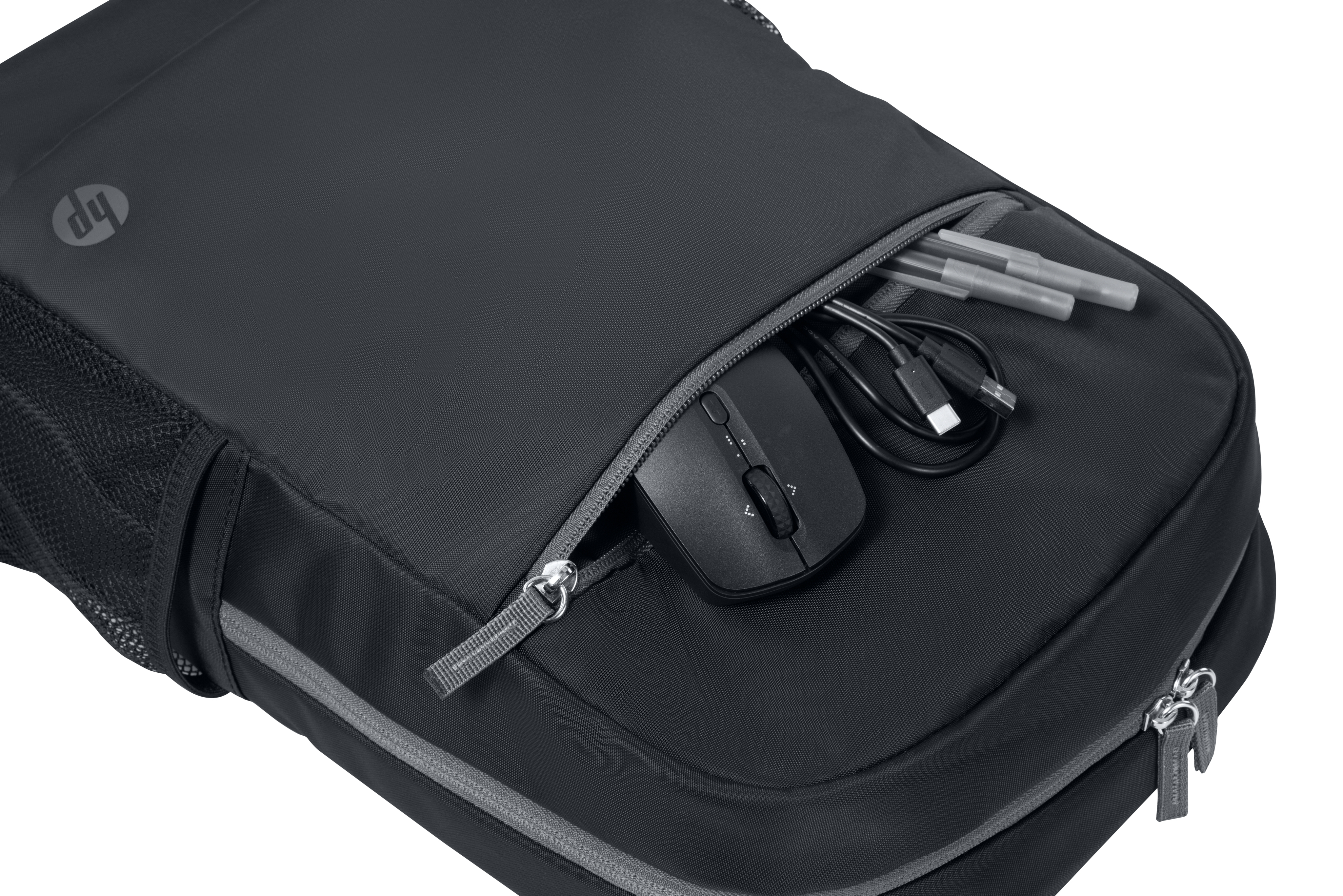 Gros plan sur la poche avant d'un sac à dos noir. À l'intérieur se trouvent une souris, des câbles et des stylos.