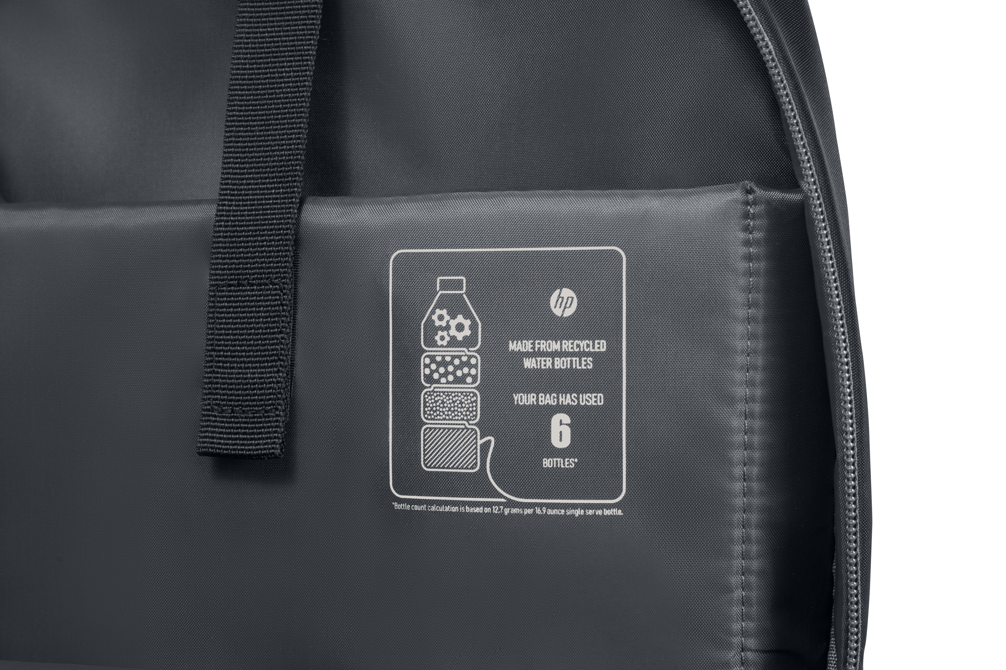 Un sac à dos HP gris foncé avec une étiquette indiquant qu'il est fabriqué à partir de bouteilles d'eau recyclées.