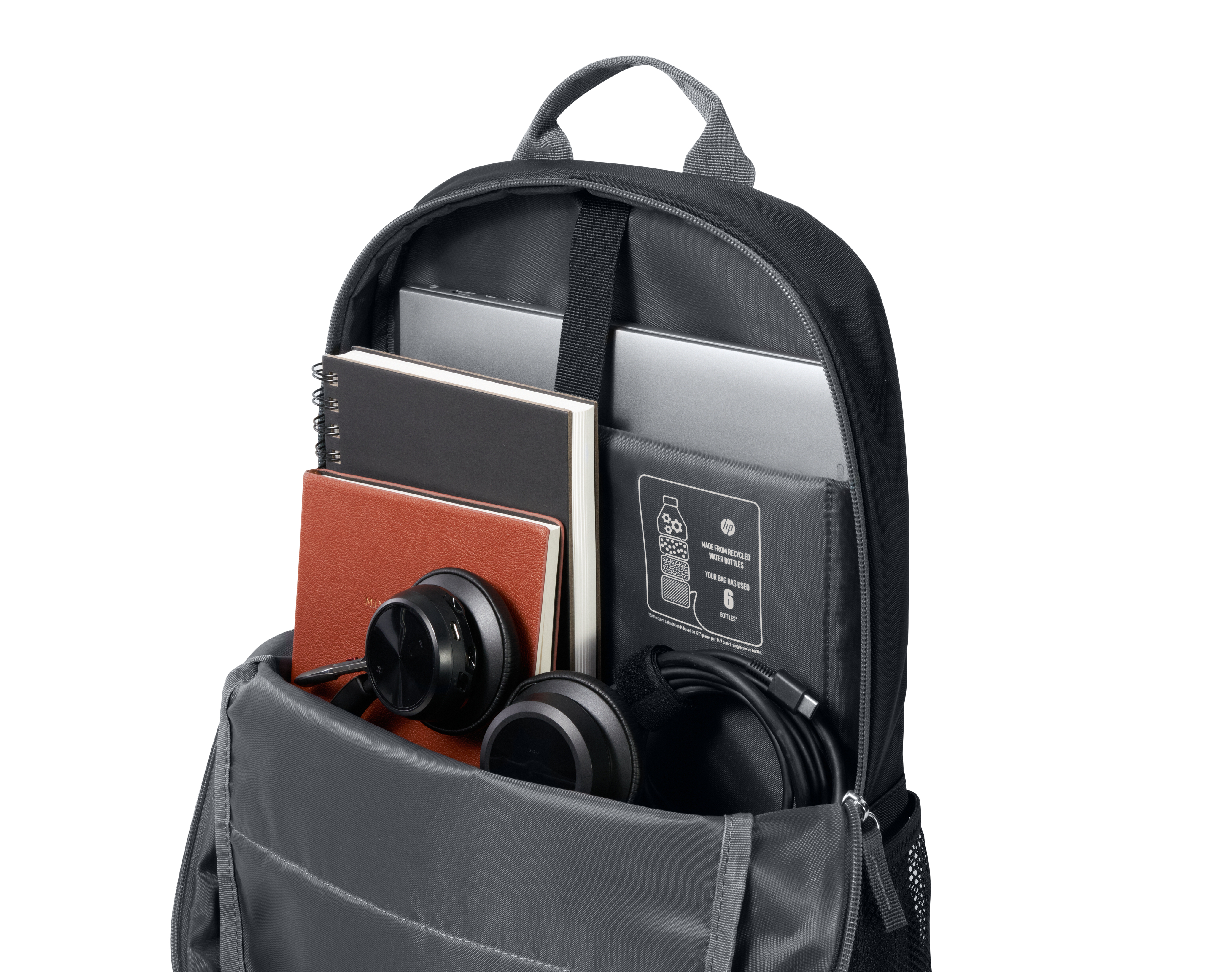 Sac à dos ouvert avec des livres, un casque et un ordinateur portable à l'intérieur. Le sac à dos est noir et gris.