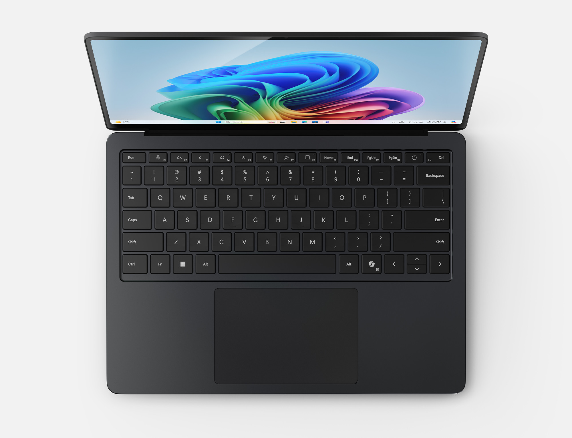 Otwarty czarny laptop, widok z góry. Widoczna klawiatura, ekran z abstrakcją.