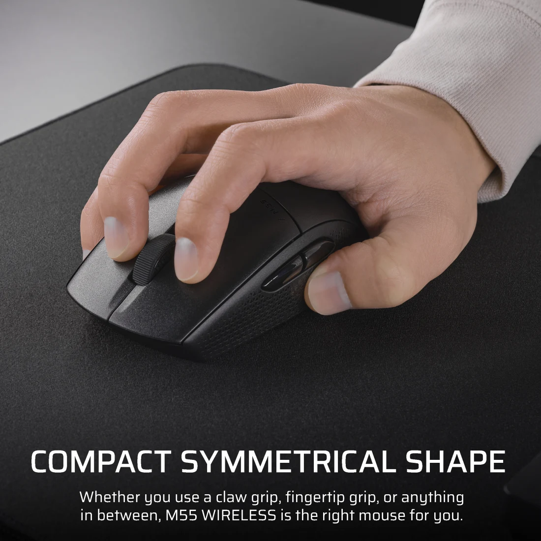 Egy kéz fekete vezeték nélküli egeret használ egérpadon. Szöveg: 'COMPACT SYMMETRICAL SHAPE'.