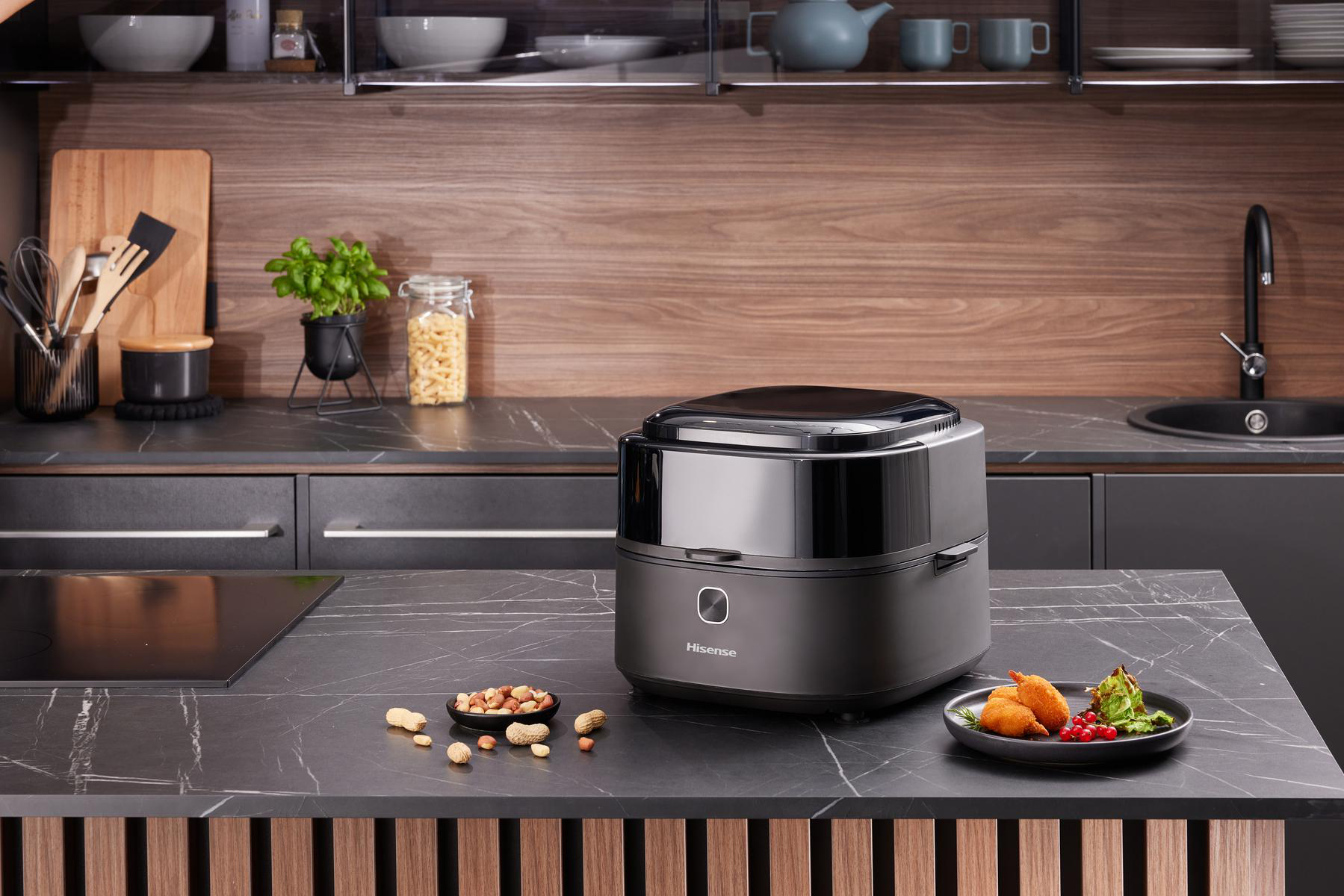 Schwarze und graue Küche mit Hisense-Gerät, Essen und Pflanzen auf der Theke.