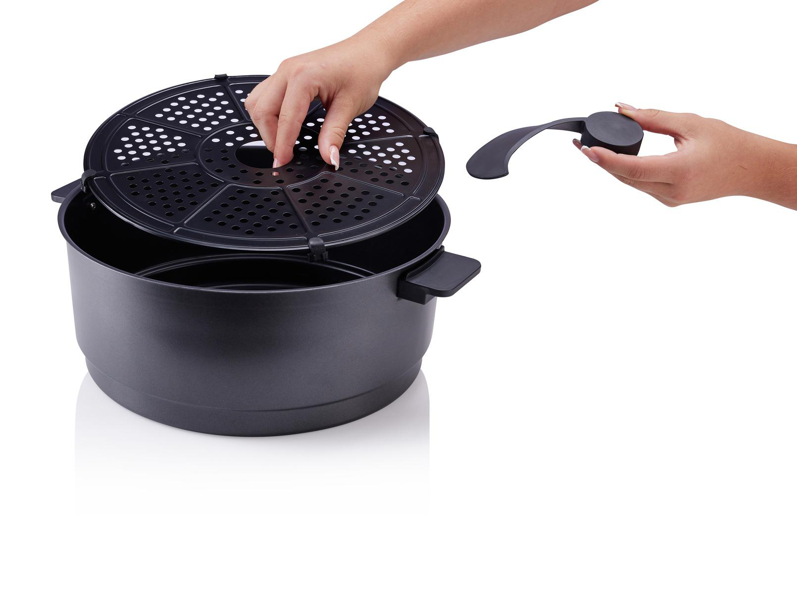 Ein schwarzer Airfryer-Korb mit Griff und Rost.