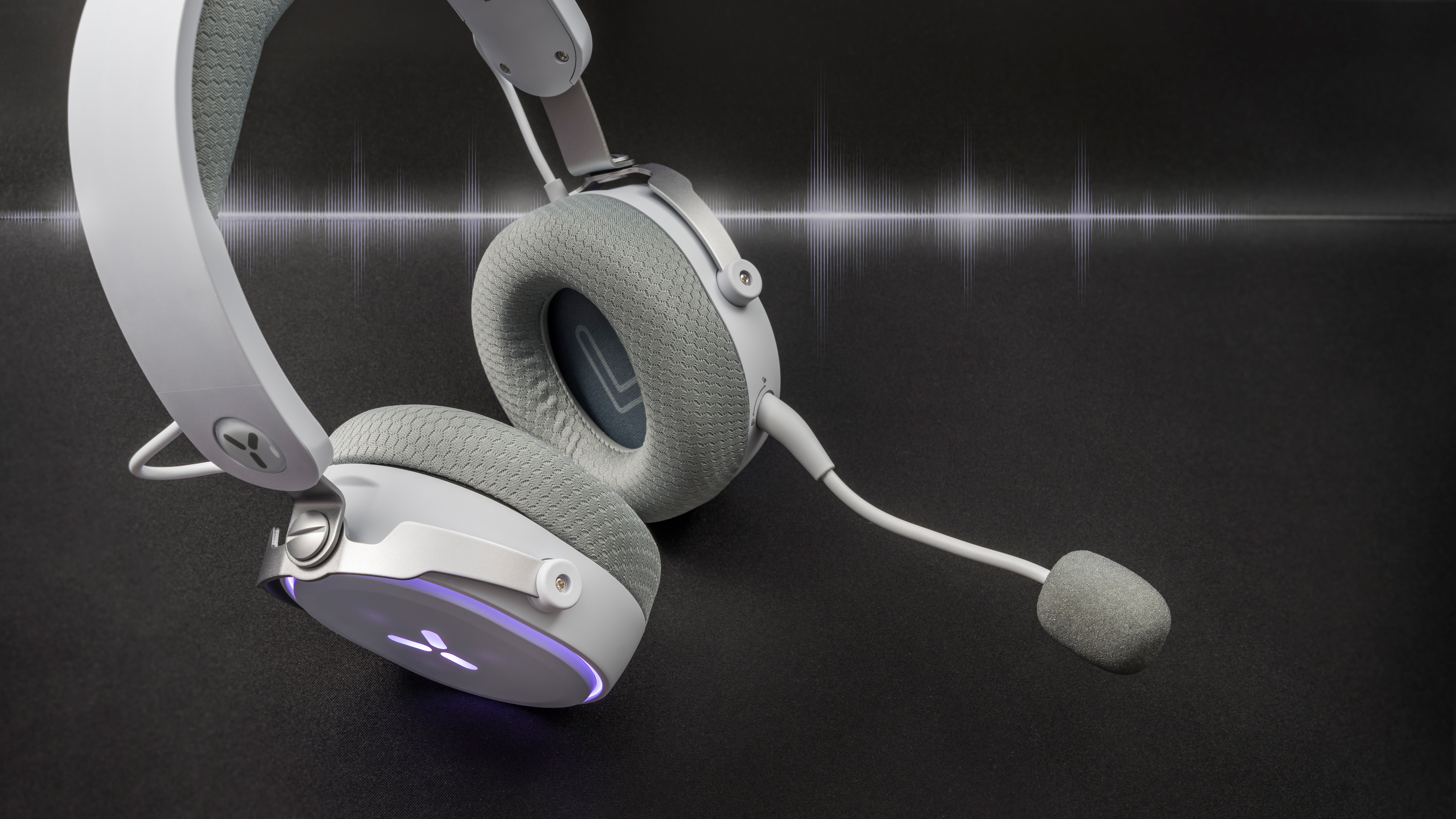 Białe słuchawki do gier z mikrofonem. Nauszniki i pałąk są wyściełane.