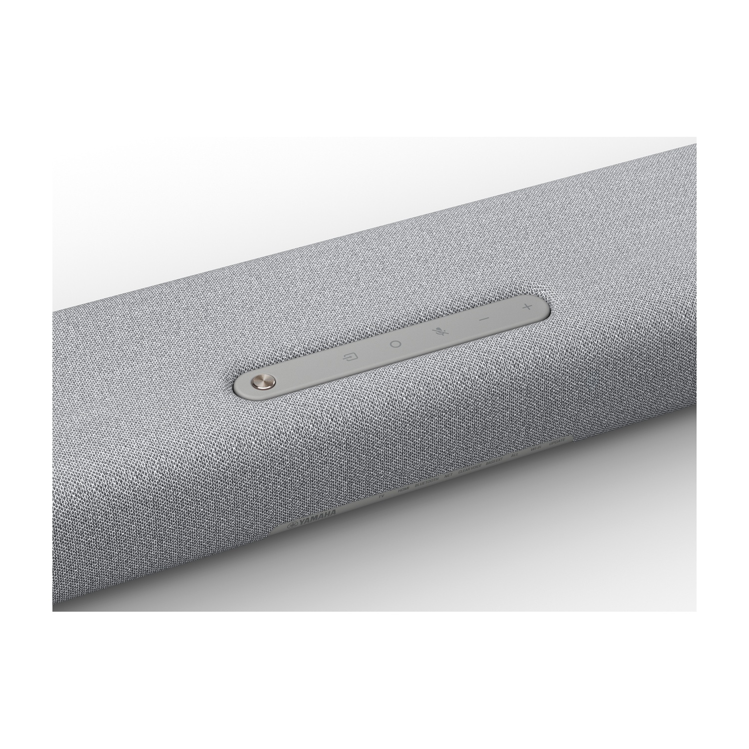 Un primo piano di una soundbar grigio chiaro con pulsanti di controllo sulla parte superiore. Lo sfondo è bianco.