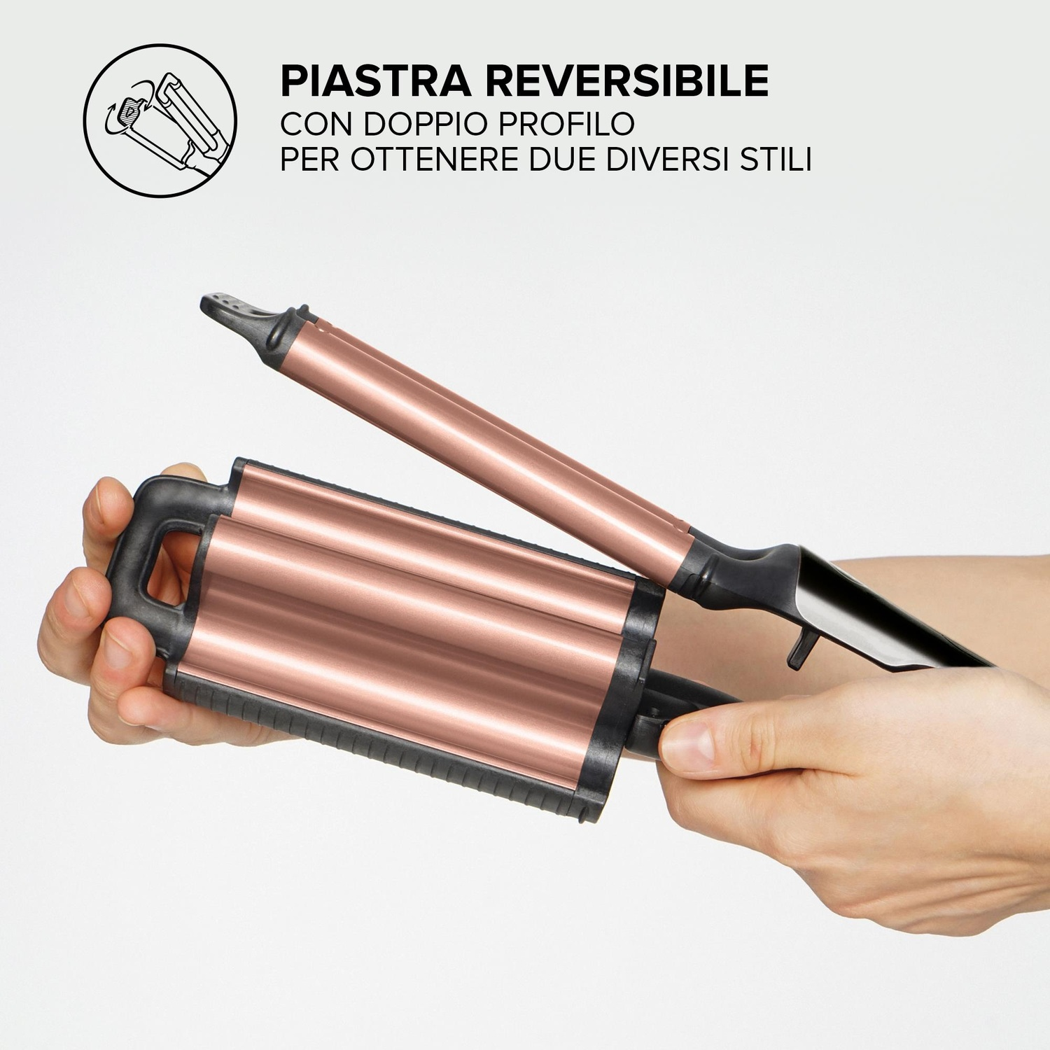 Strumento per lo styling dei capelli reversibile tenuto in mano, color rame.