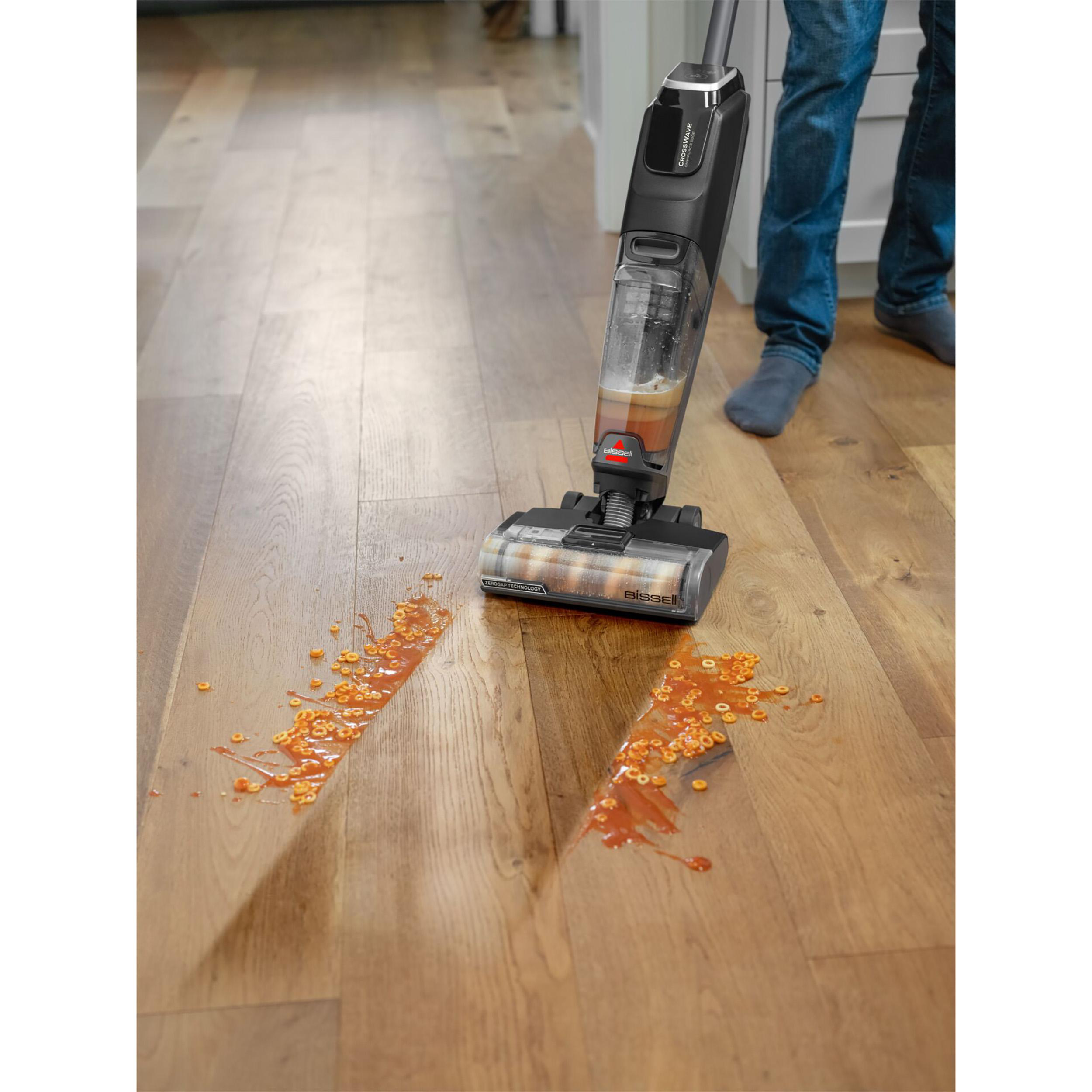 Person reinigt mit einem Bodenreiniger einen verschütteten Frühstücksflocken.