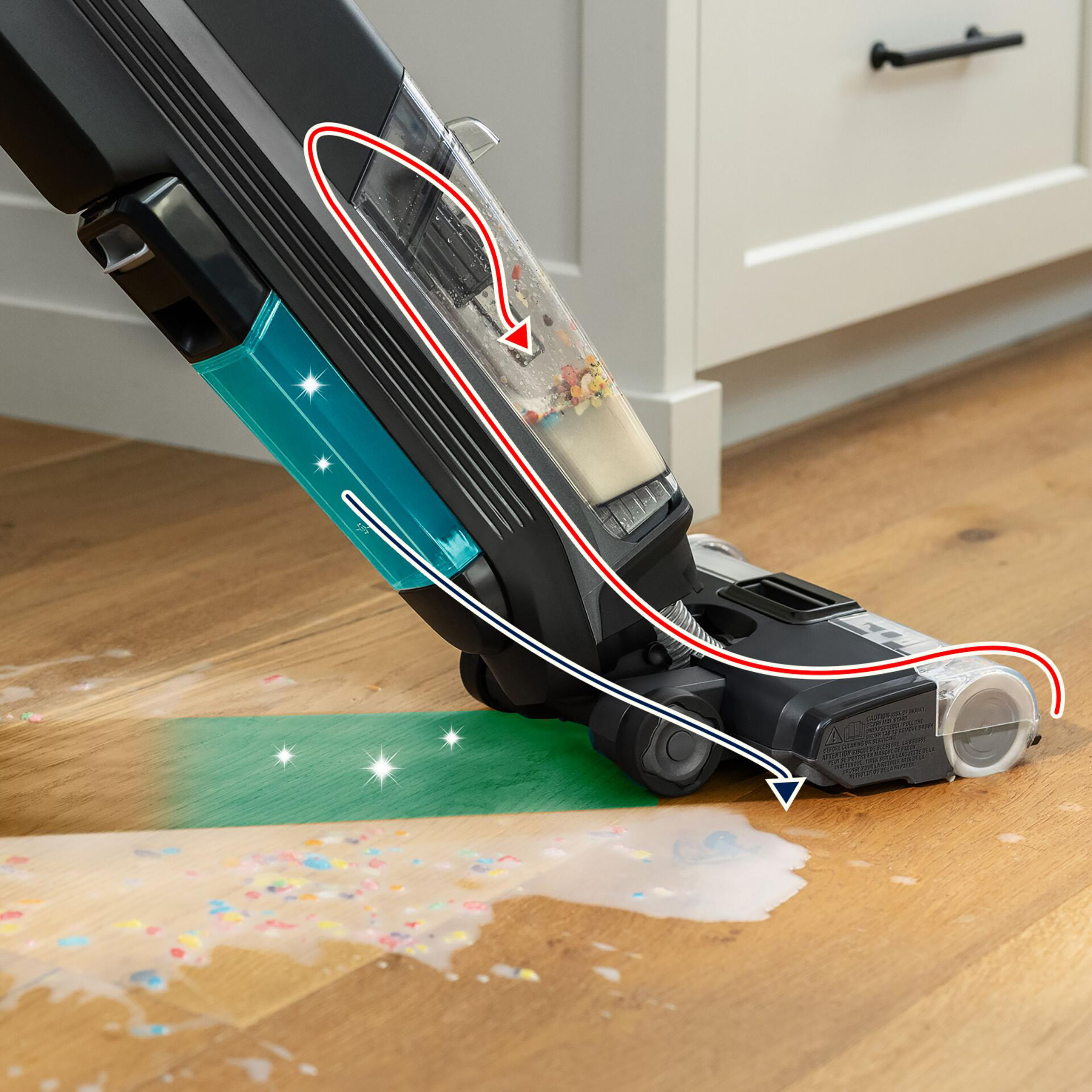 Staubsauger reinigt Boden. Wasser, Konfetti und Saugpfad sichtbar. Schwarz und türkis.
