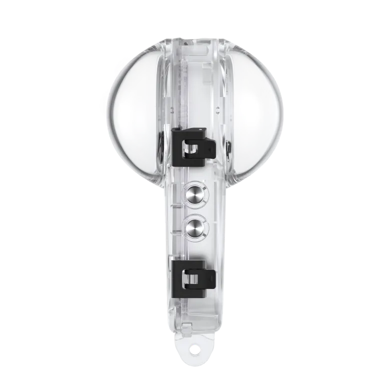 Dispositivo de plástico transparente con clips negros. Parte superior e inferior redondeadas, dos botones plateados.