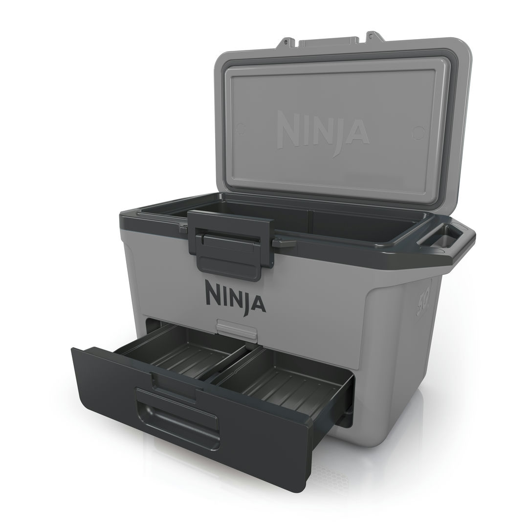 Egy Ninja hűtő nyitott fedéllel és kihúzott fiókkal. A hűtő szürke és fekete.