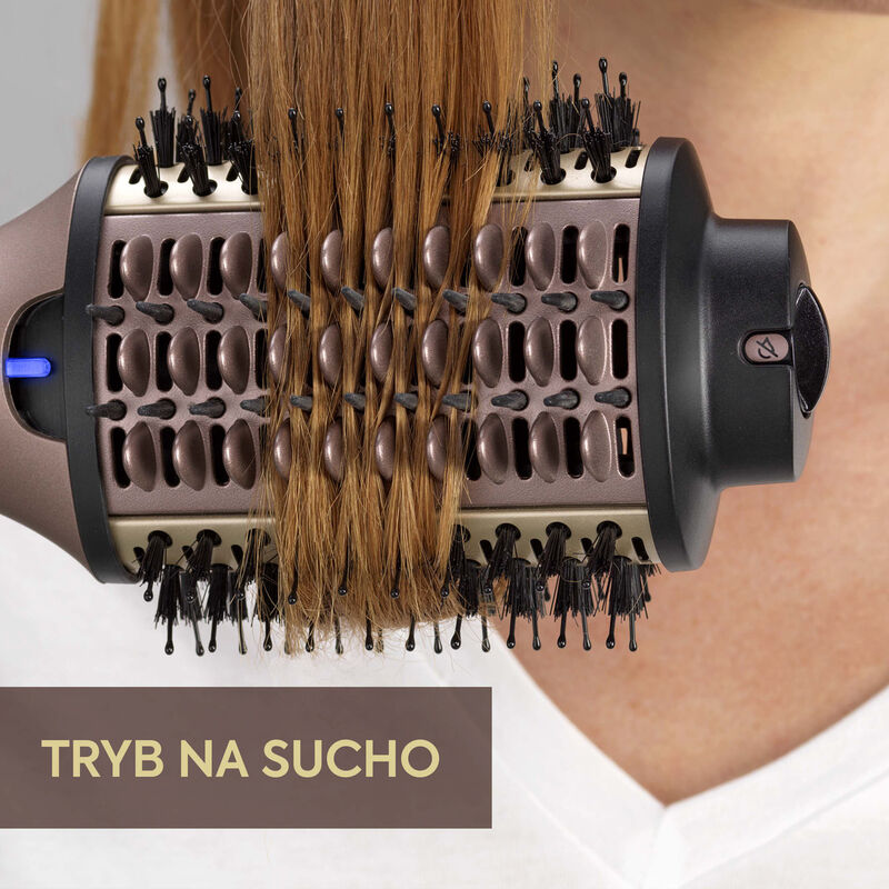Zbliżenie obrotowej szczotki do stylizacji włosów z włosami. Tekst: 'Tryb na sucho' (Tryb suchy).