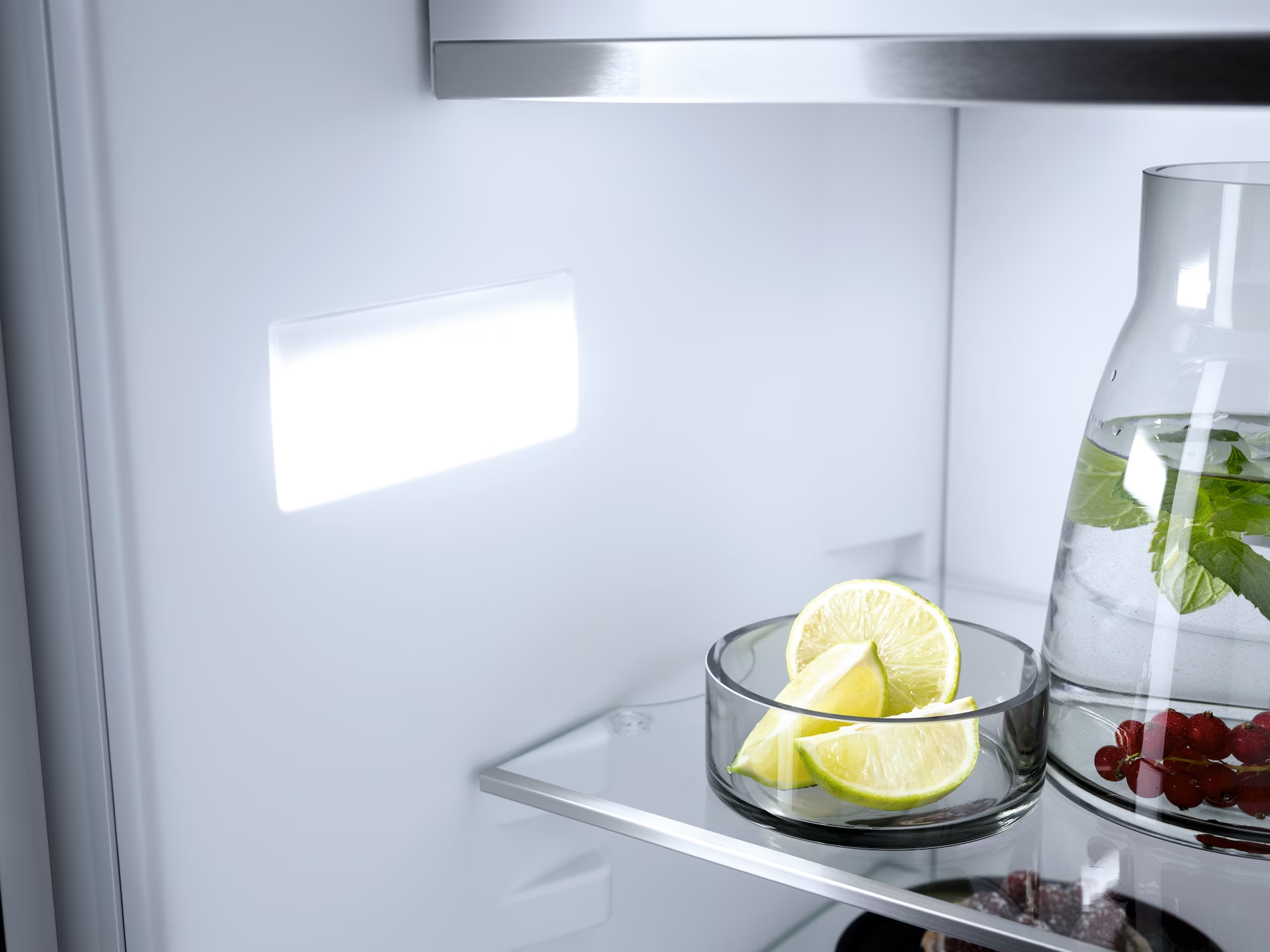 Interno del frigorifero con luce e una ciotola con fette di lime.