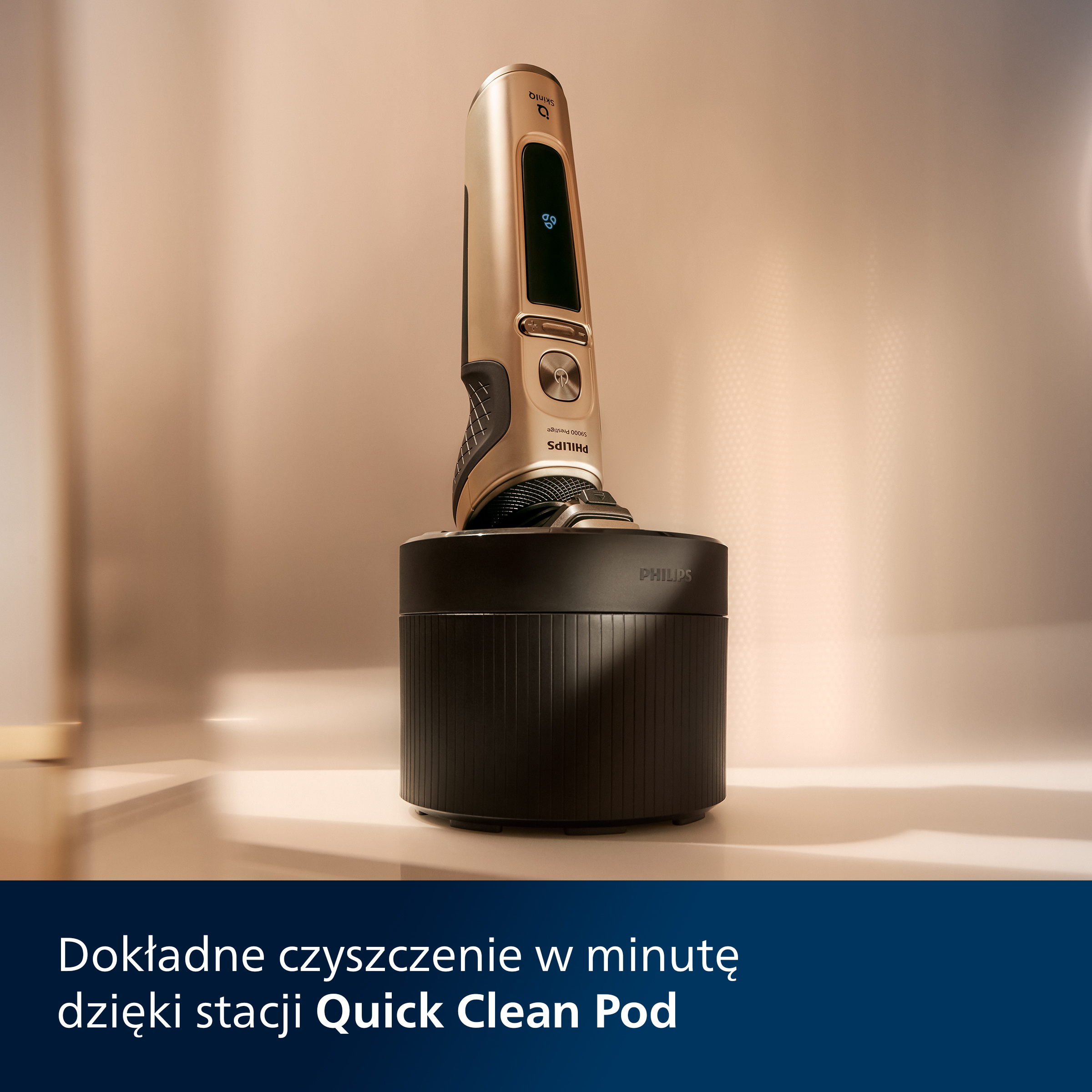 Złota golarka Philips w czarnej stacji ładującej na białej powierzchni. Tekst mówi 'Quick Clean Pod'.