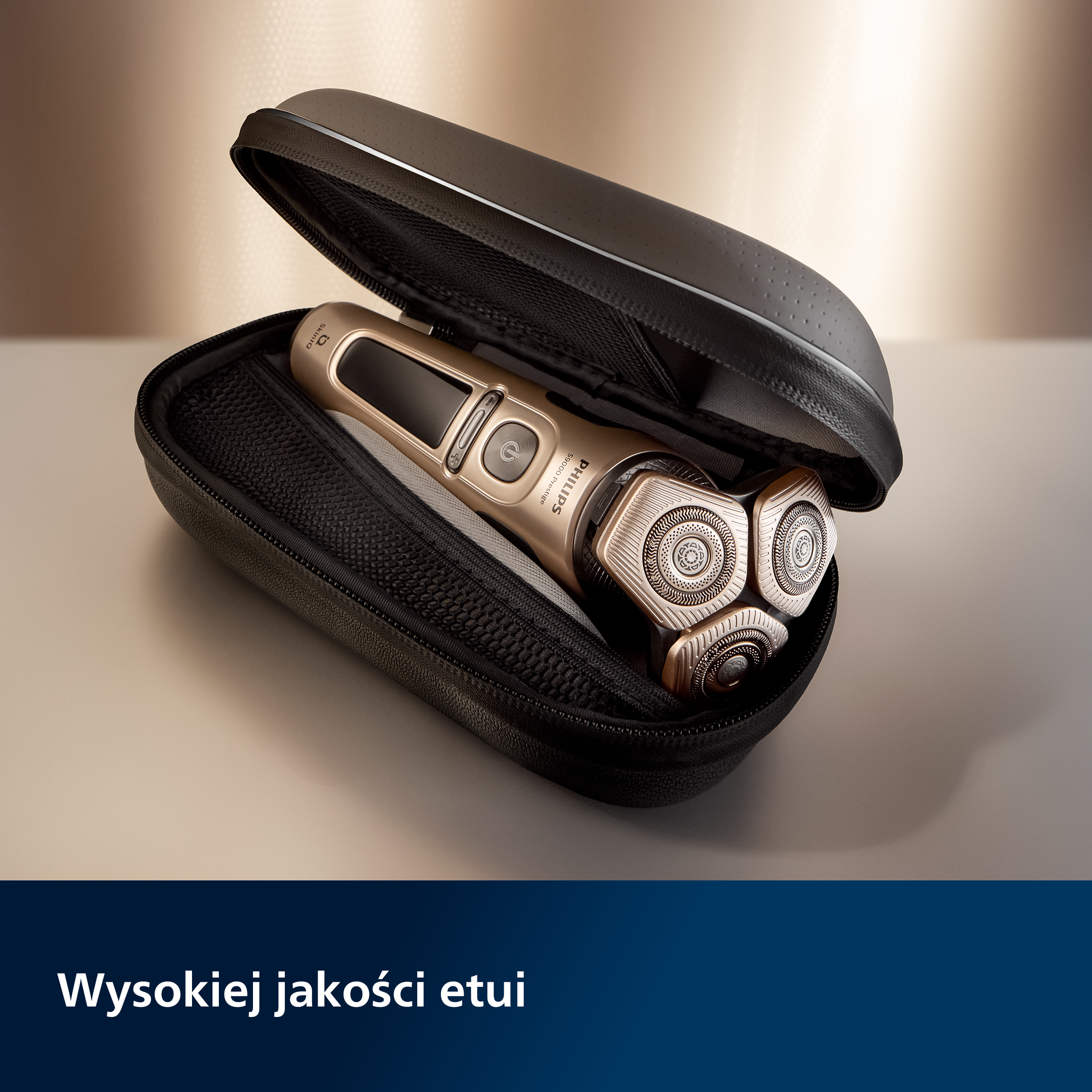 Złota golarka w czarnym etui. Etui jest otwarte, a golarka widoczna.