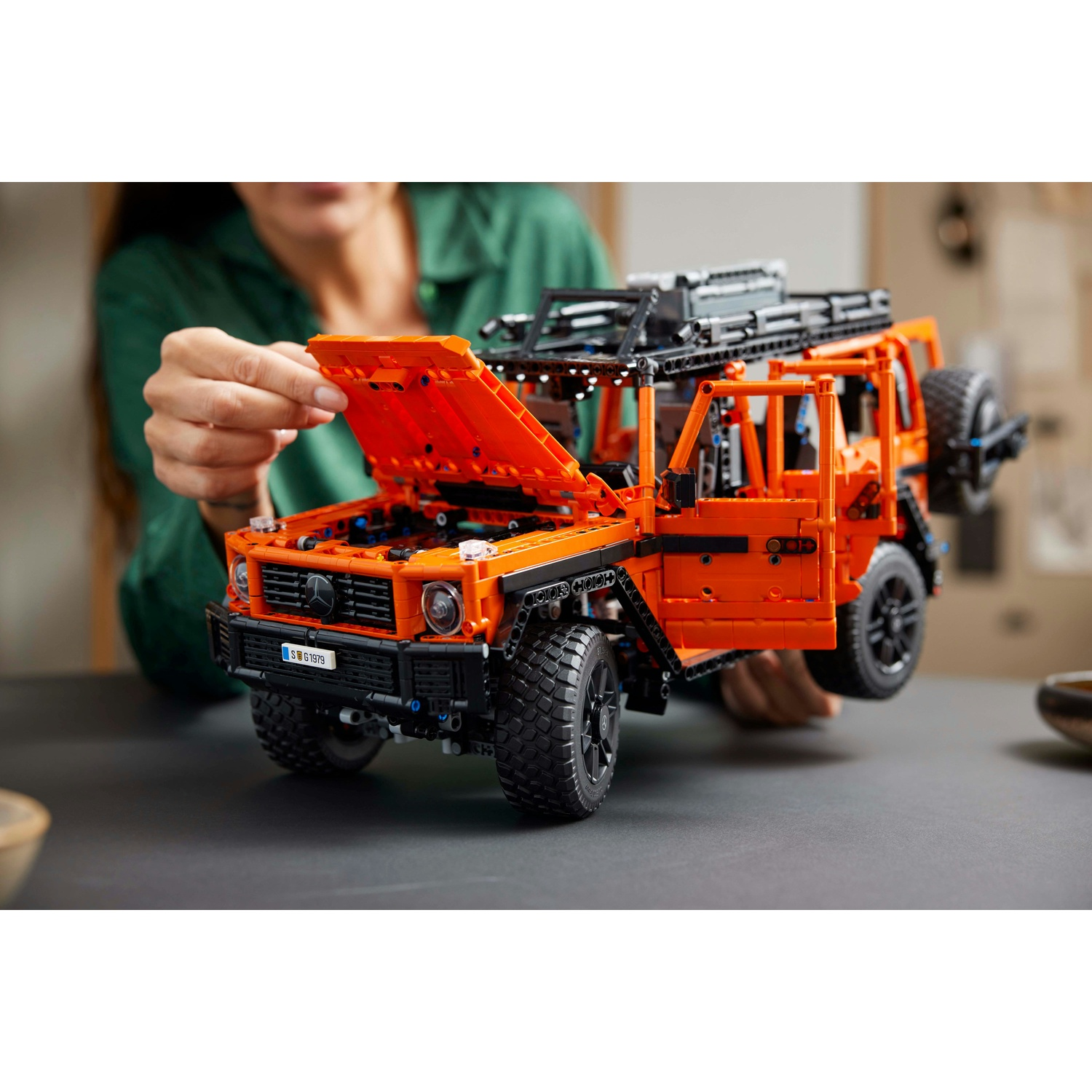 Un veicolo fuoristrada Mercedes-Benz Lego Technic arancione, parzialmente assemblato.