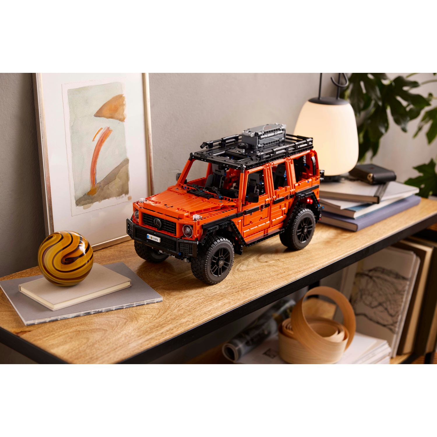 Modello di auto Lego su una mensola. L'auto è arancione e nera.