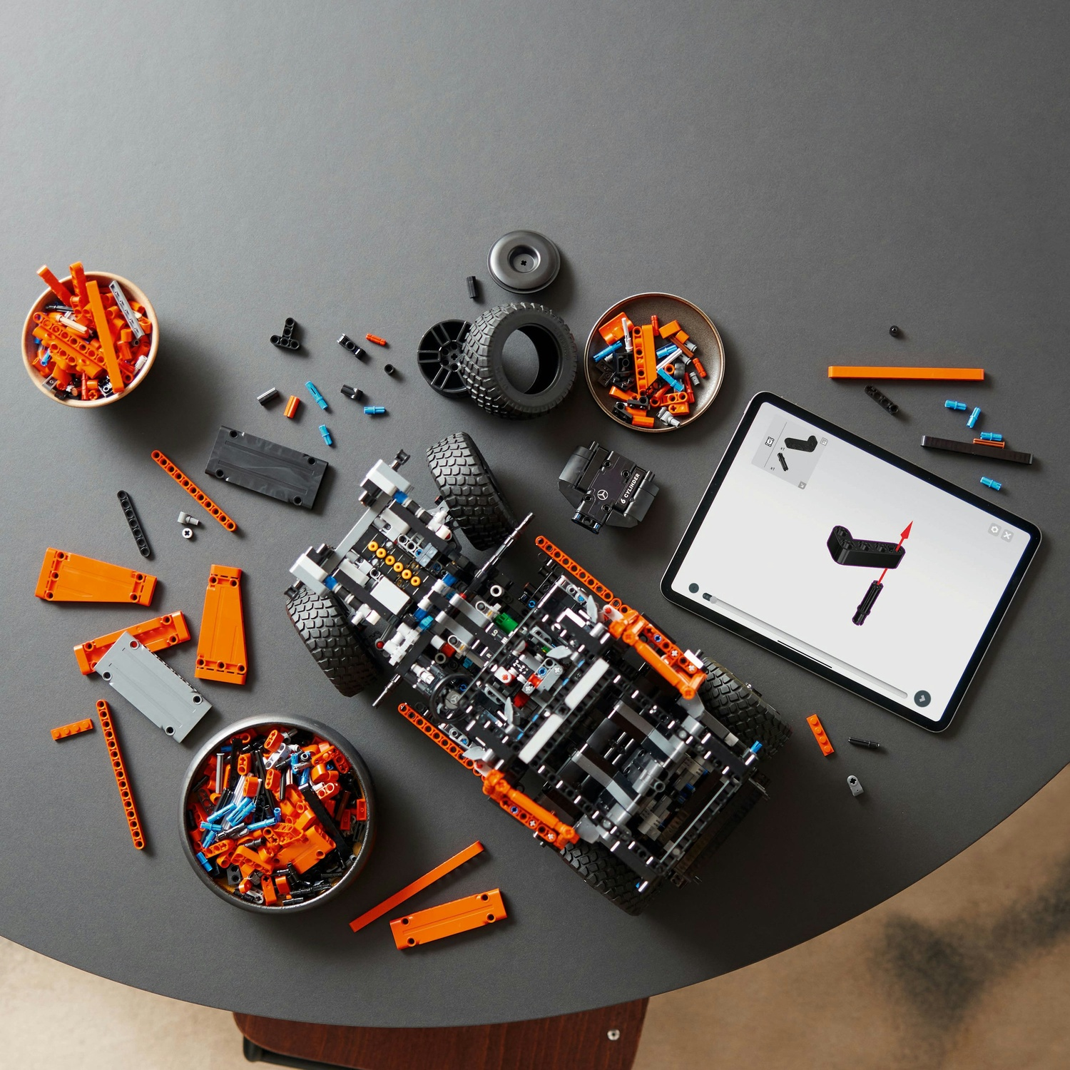 Set di costruzione auto Lego. Parti in ciotole, tablet con istruzioni.