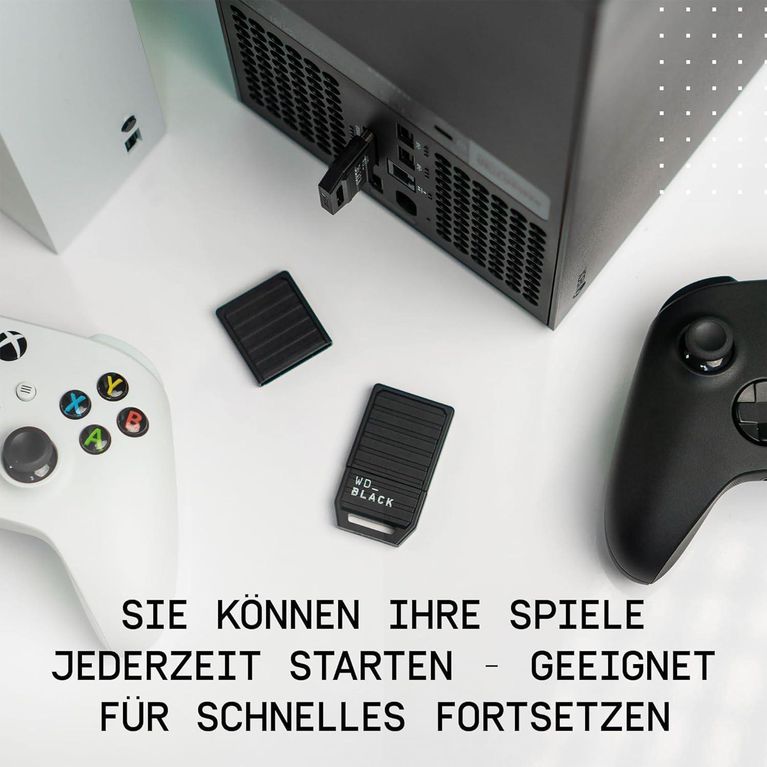 Eine Draufsicht auf ein weißes und schwarzes Gaming-Setup mit Controllern und externen Festplatten.